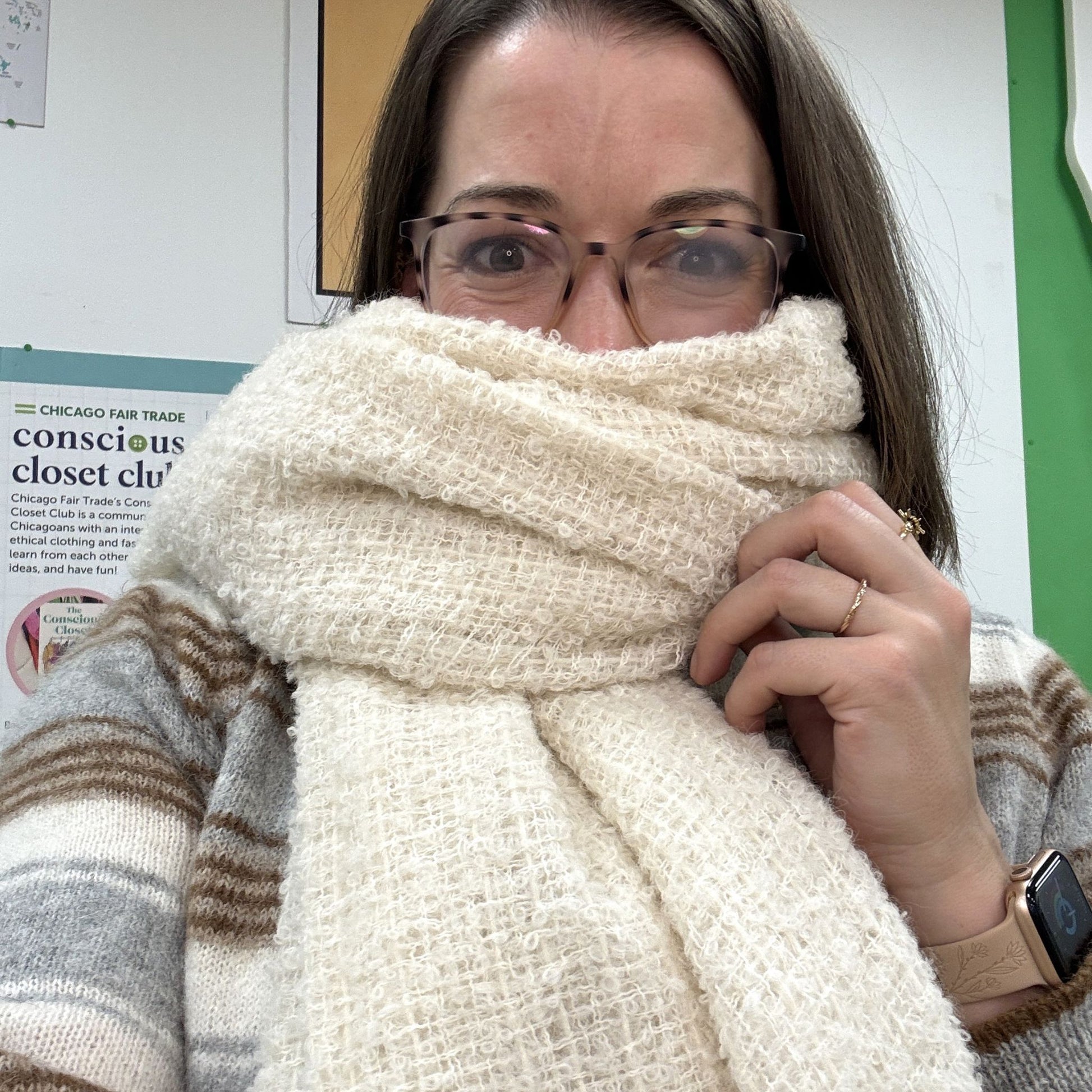 Person wearing a large white scarf over their face with a blurred background