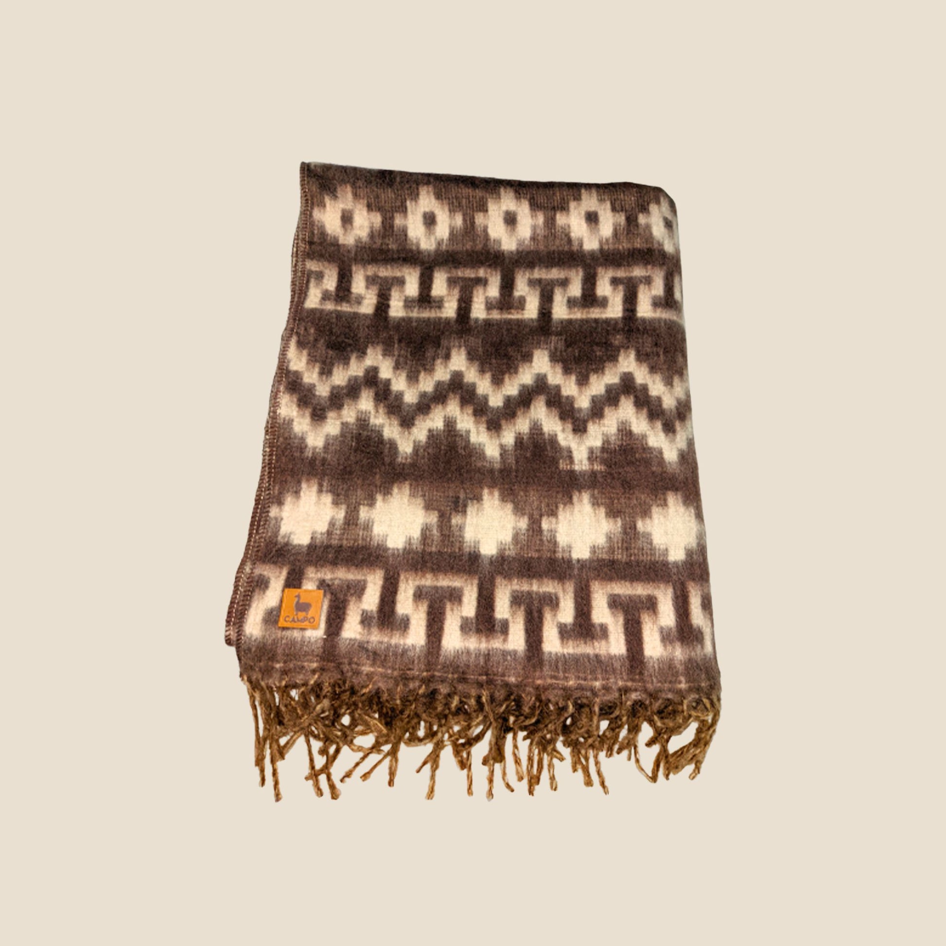 Woven blanket with geometric pattern and fringes on a beige background