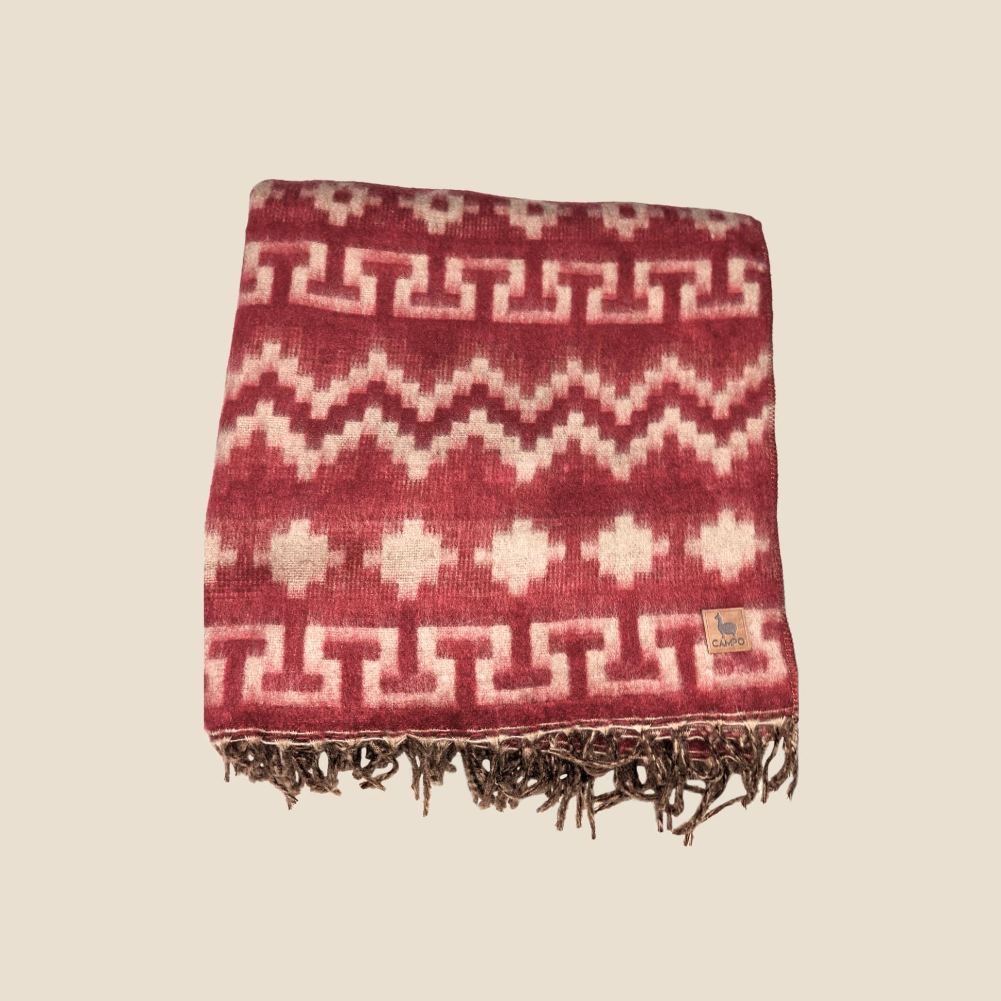 Woven blanket with geometric pattern on a beige background