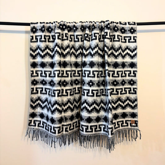 Black and white patterned scarf with fringes on a beige background
