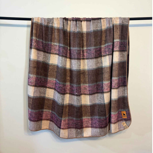 Plaid blanket draped over a rack against a white wall
