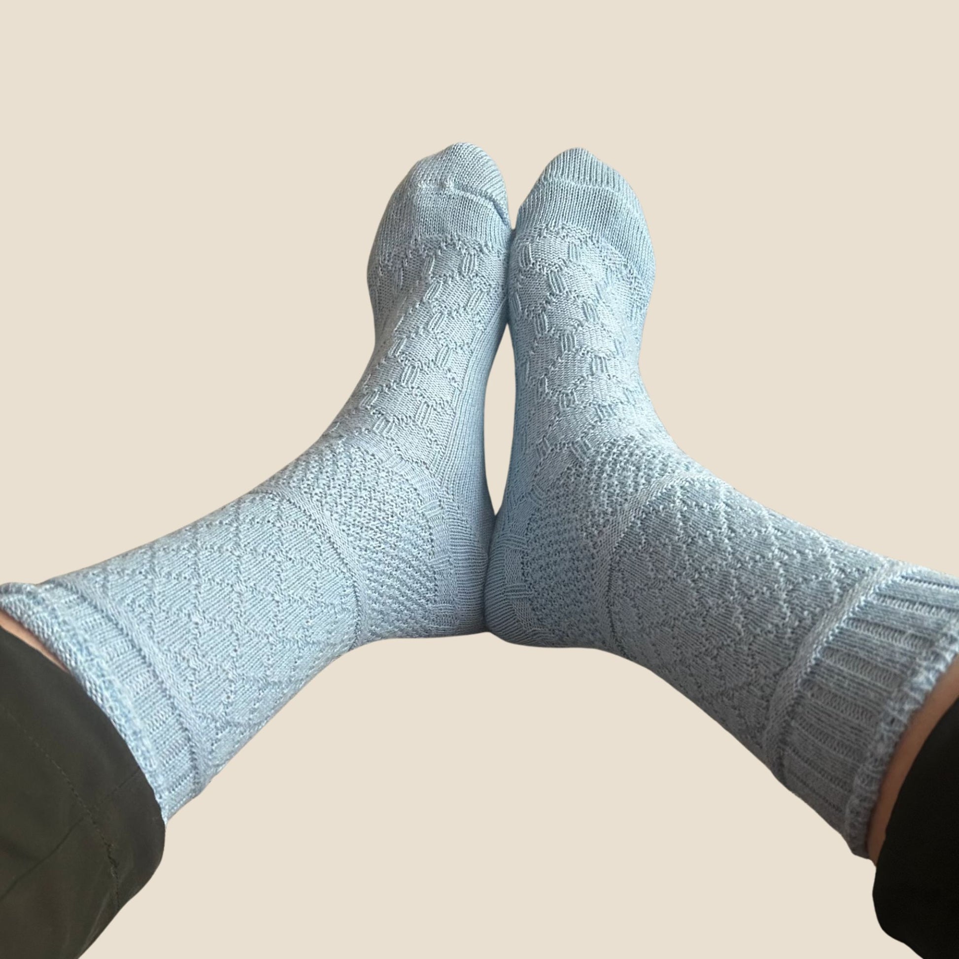 blue textured socks worn on a beige background