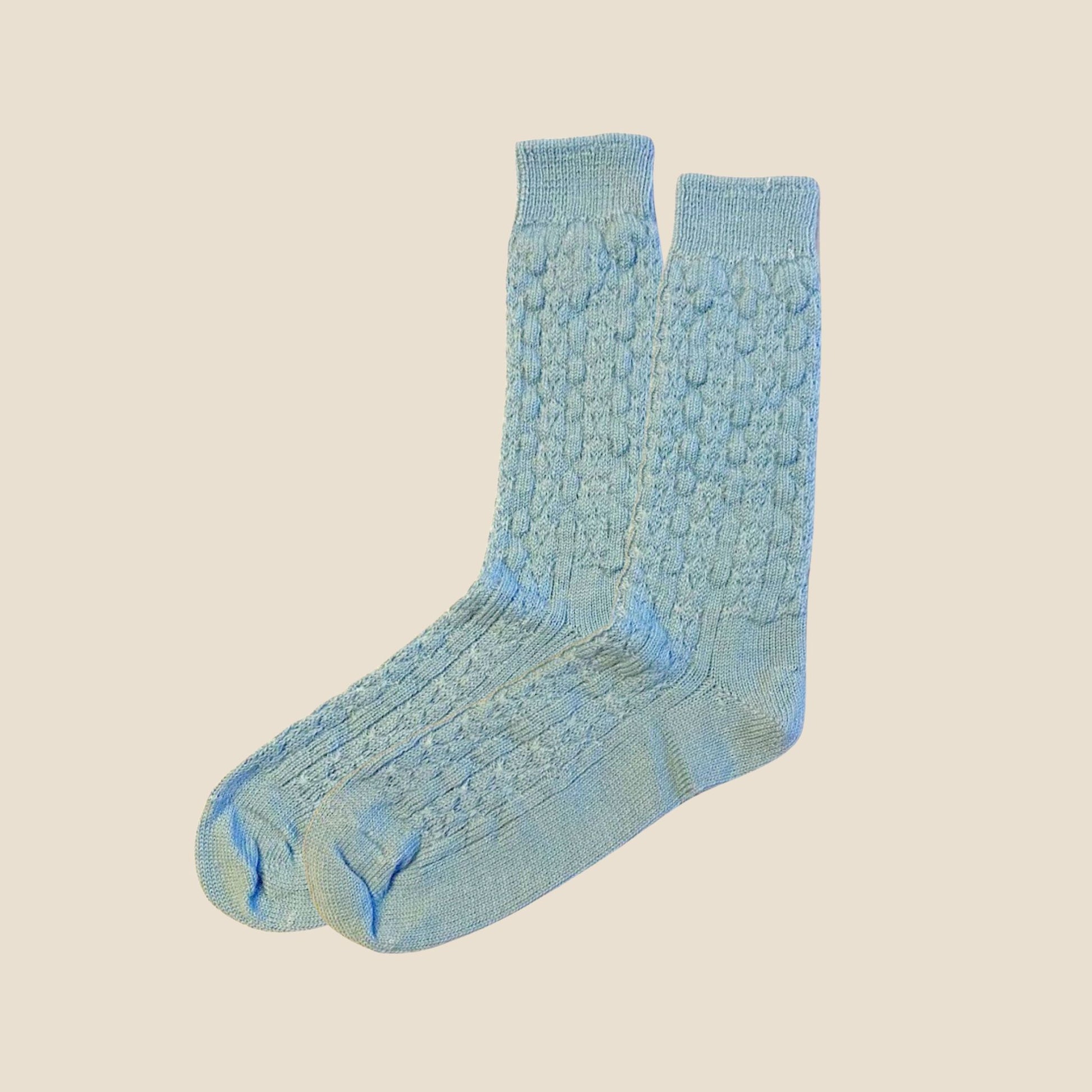 Pair of blue textured socks on a beige background