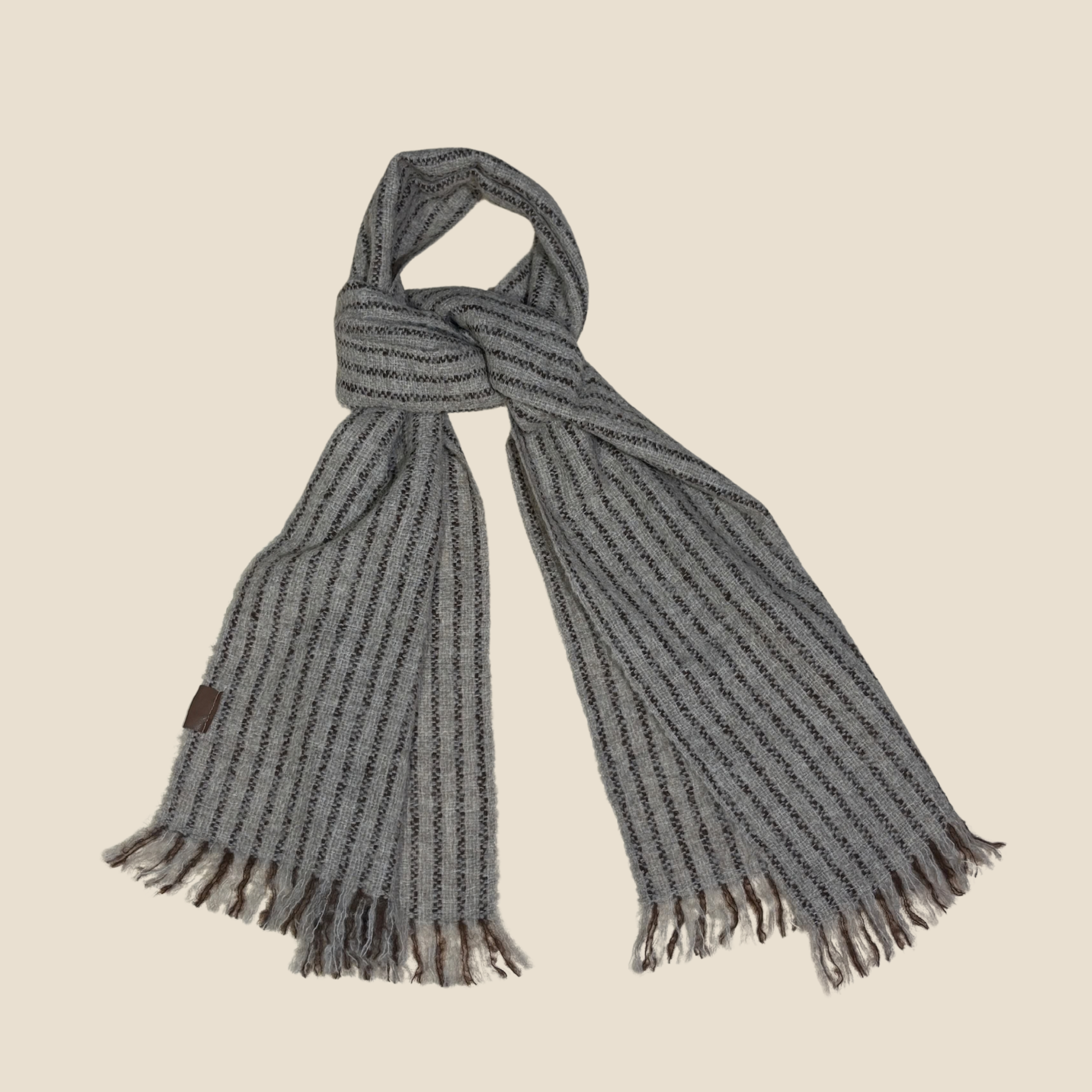Gray scarf with fringes on a beige background
