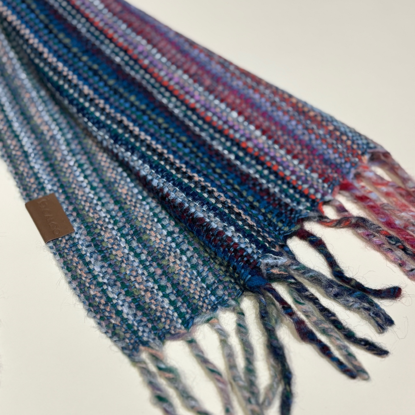Multicolored plaid scarf with tassels on a light background