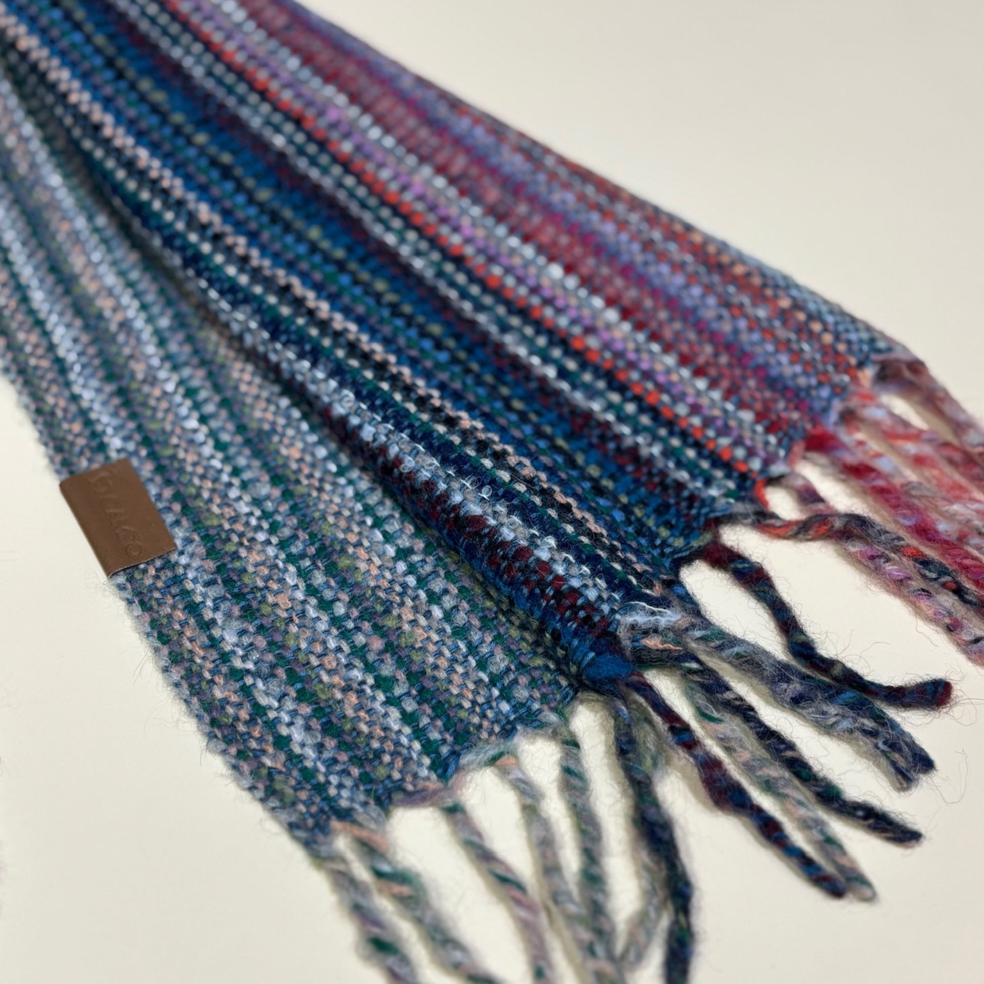 Multicolored plaid scarf with tassels on a light background