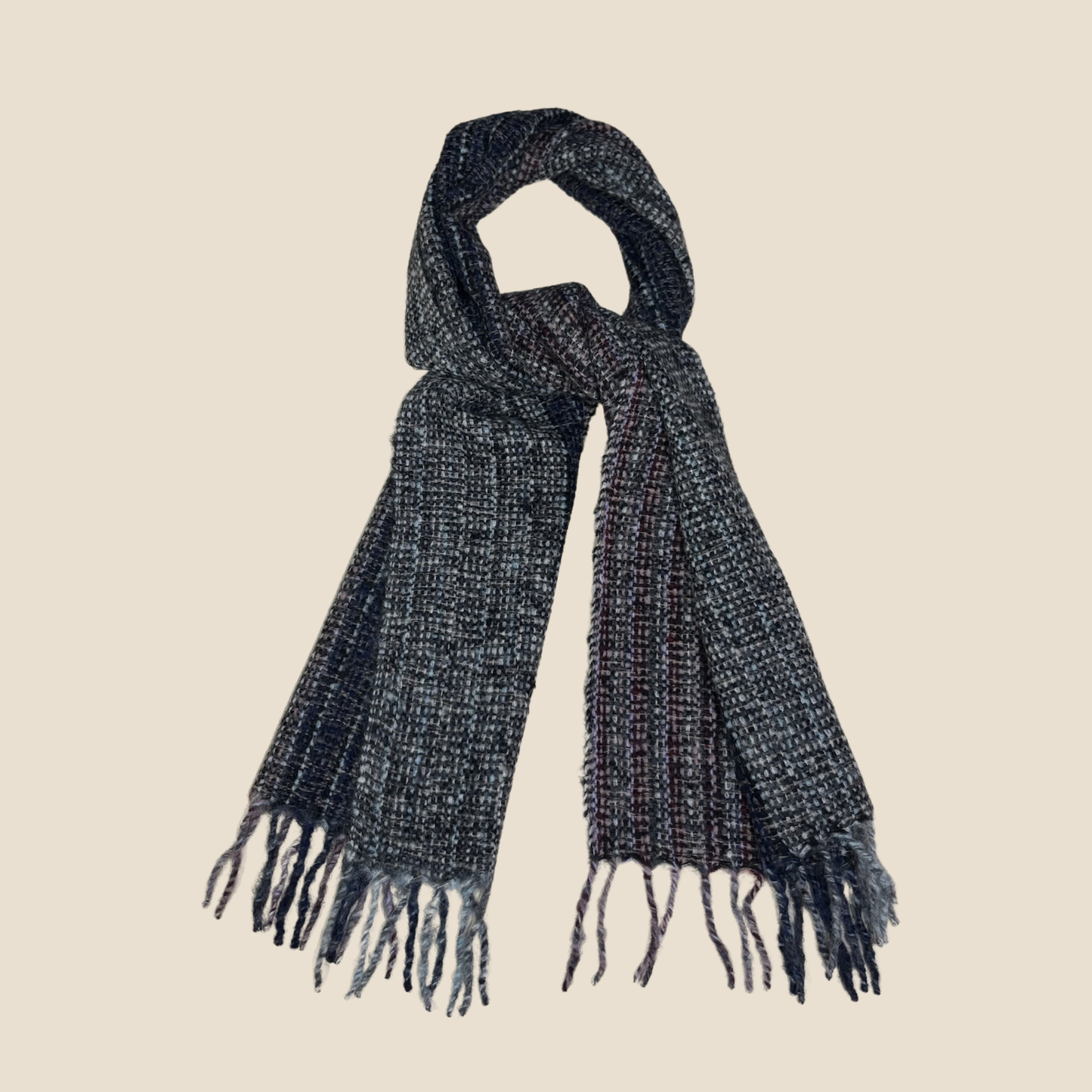 Dark gray knitted scarf with fringes on a beige background