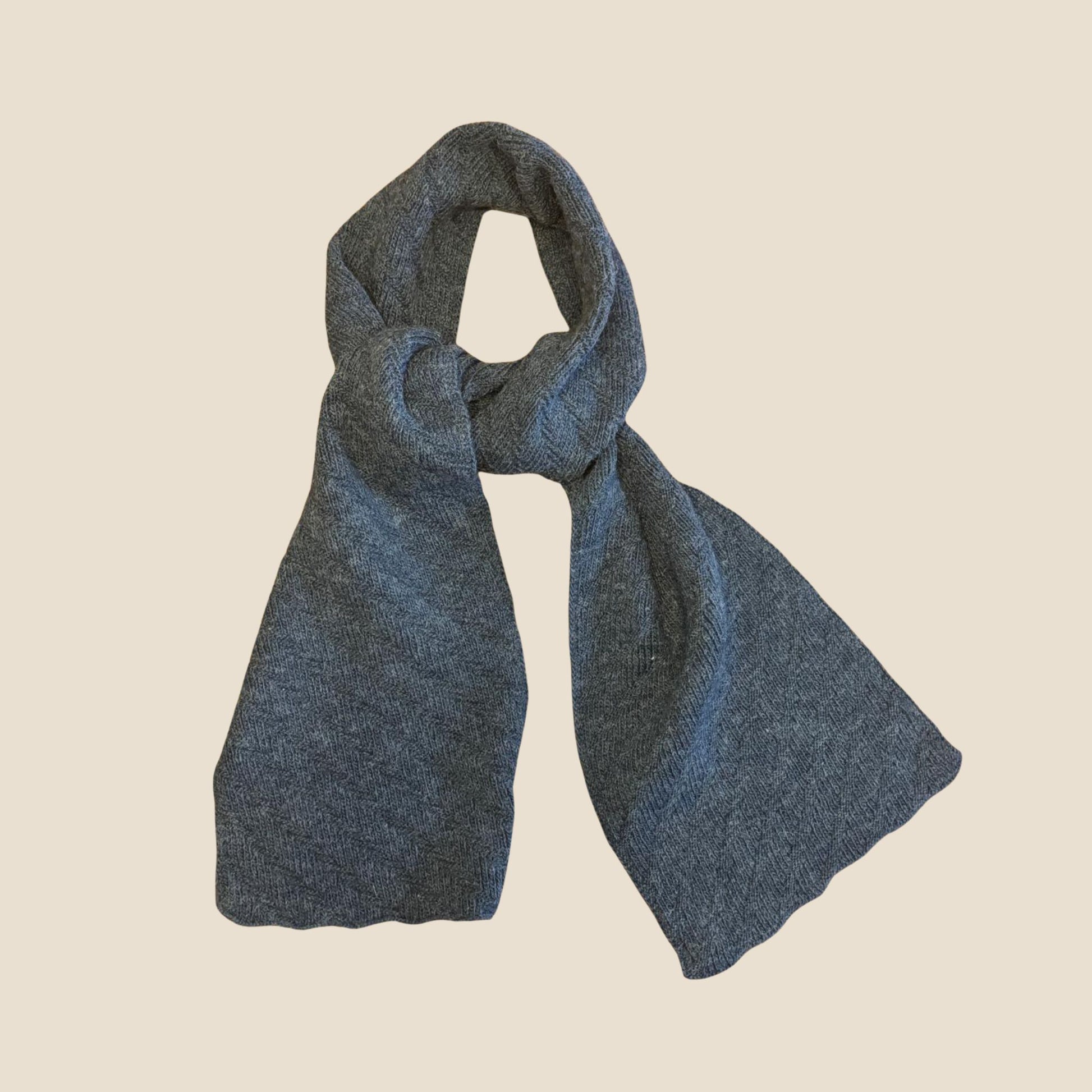 Denim blue knitted scarf on a beige background