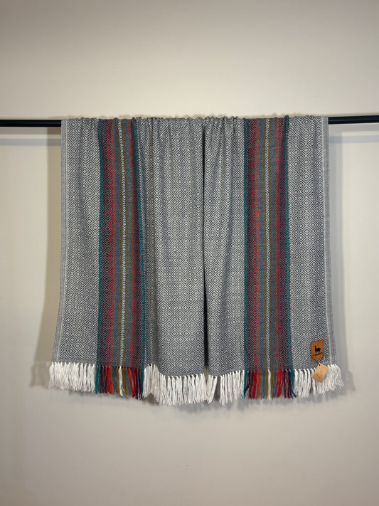 Textile with striped pattern and fringes on a plain background
