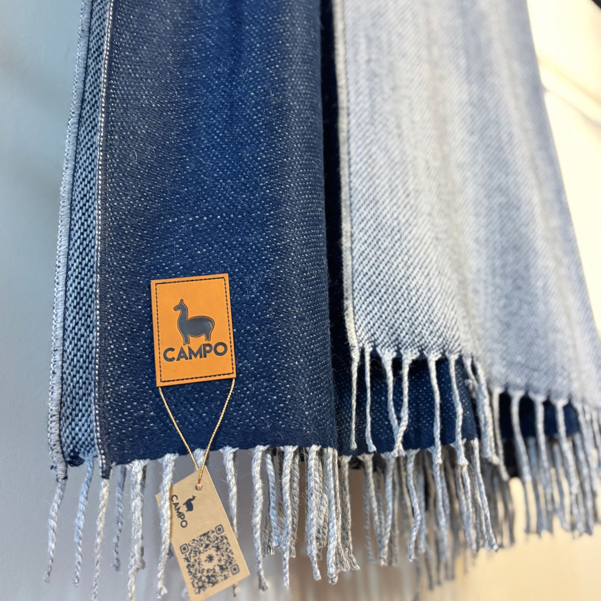 Blue and gray striped scarf with a 'Campo' brand tag on a light background