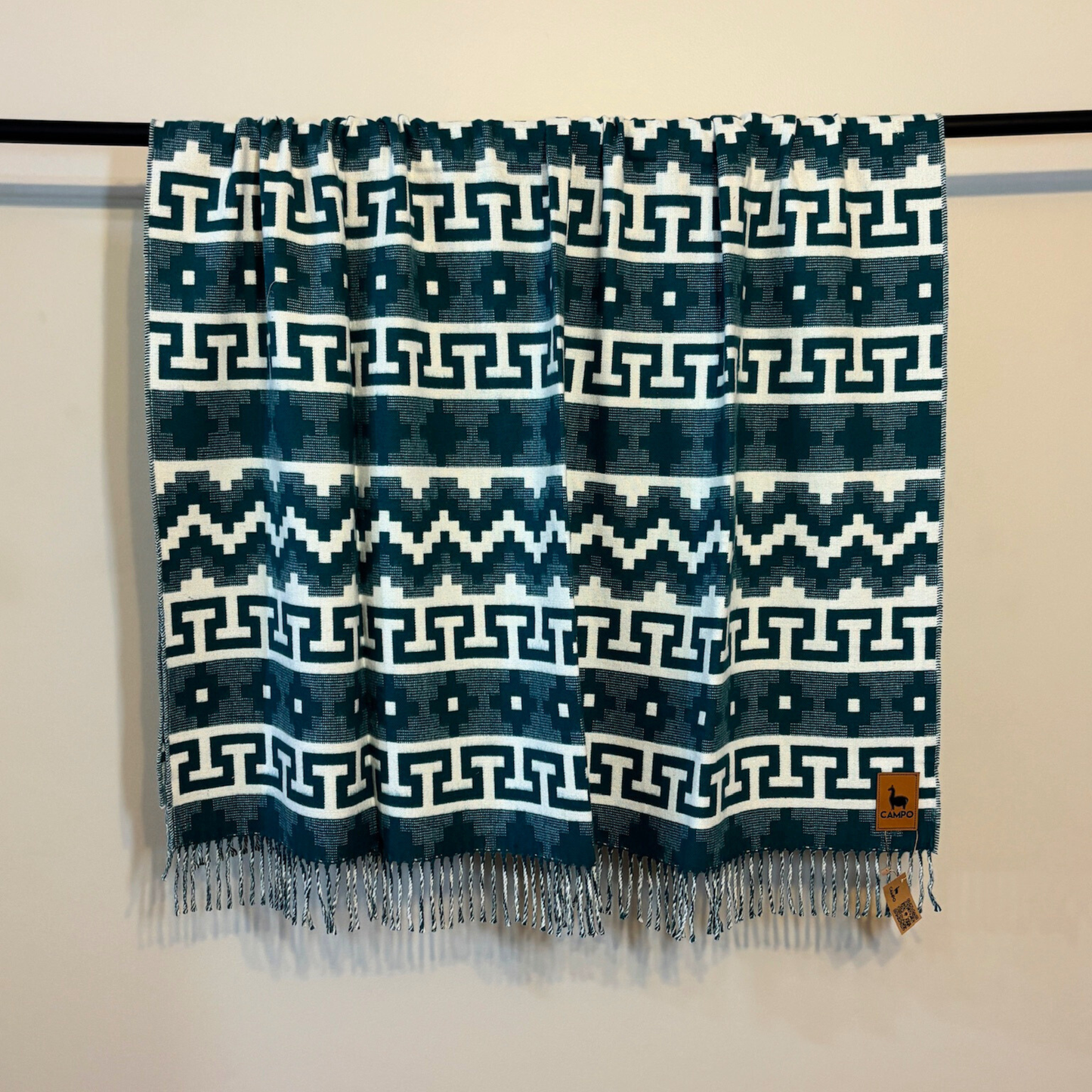 Textile with geometric pattern on a rod against a neutral background