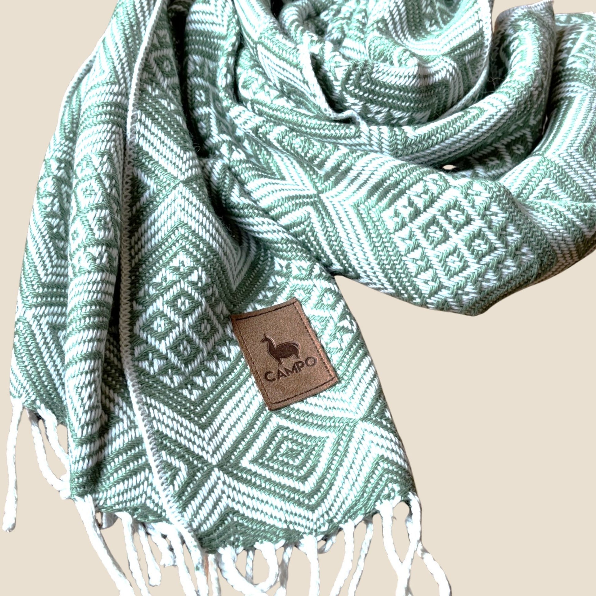Sage patterned scarf with a brand tag on a beige background