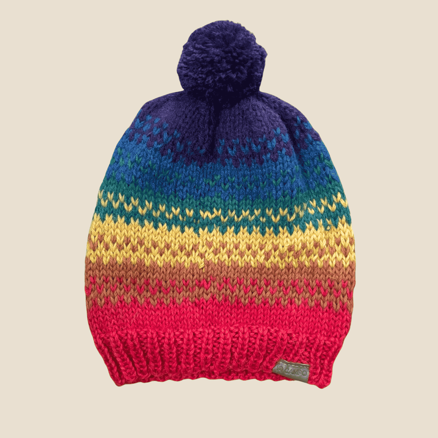 Handcrafted Rainbow Beanie made from soft alpaca wool, laid flat to display its full colorful striped pattern and cozy knitted design