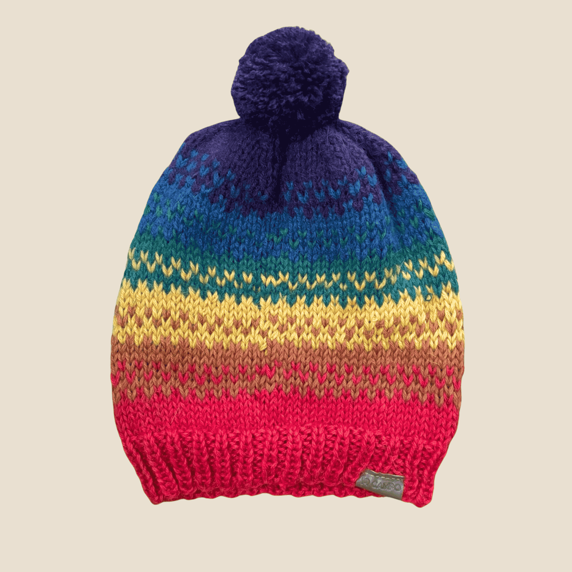 Handcrafted Rainbow Beanie made from soft alpaca wool, laid flat to display its full colorful striped pattern and cozy knitted design