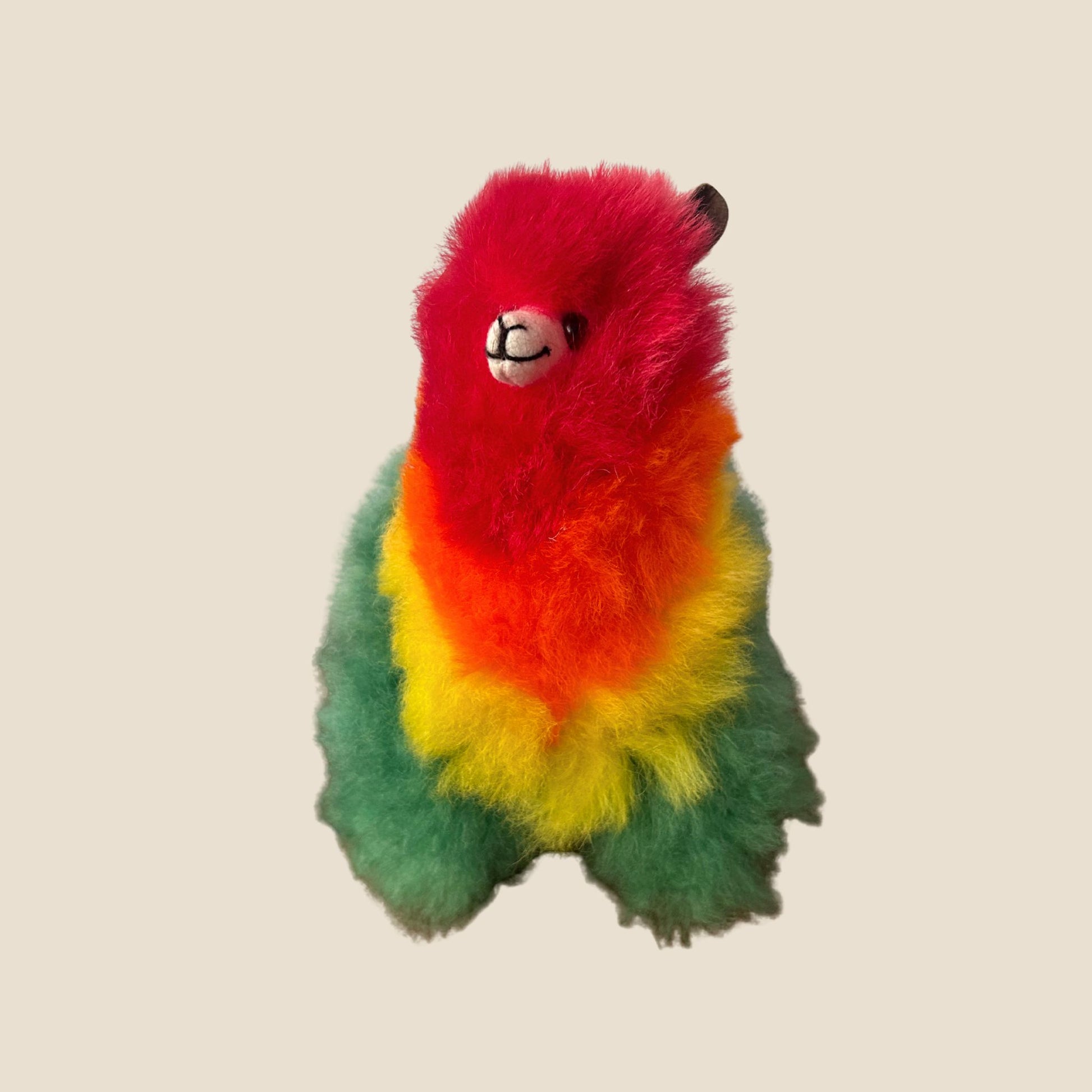 Colorful plush toy resembling a alpaca on a beige background
