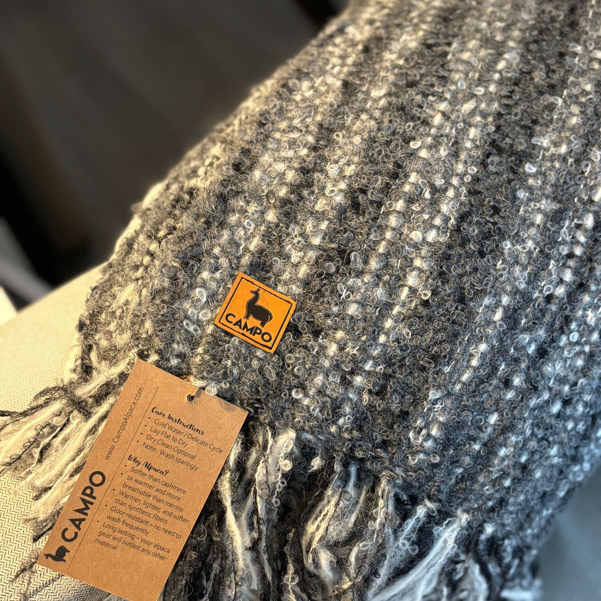 Gray textured fabric with a 'CAMPQ' label and brown tag.