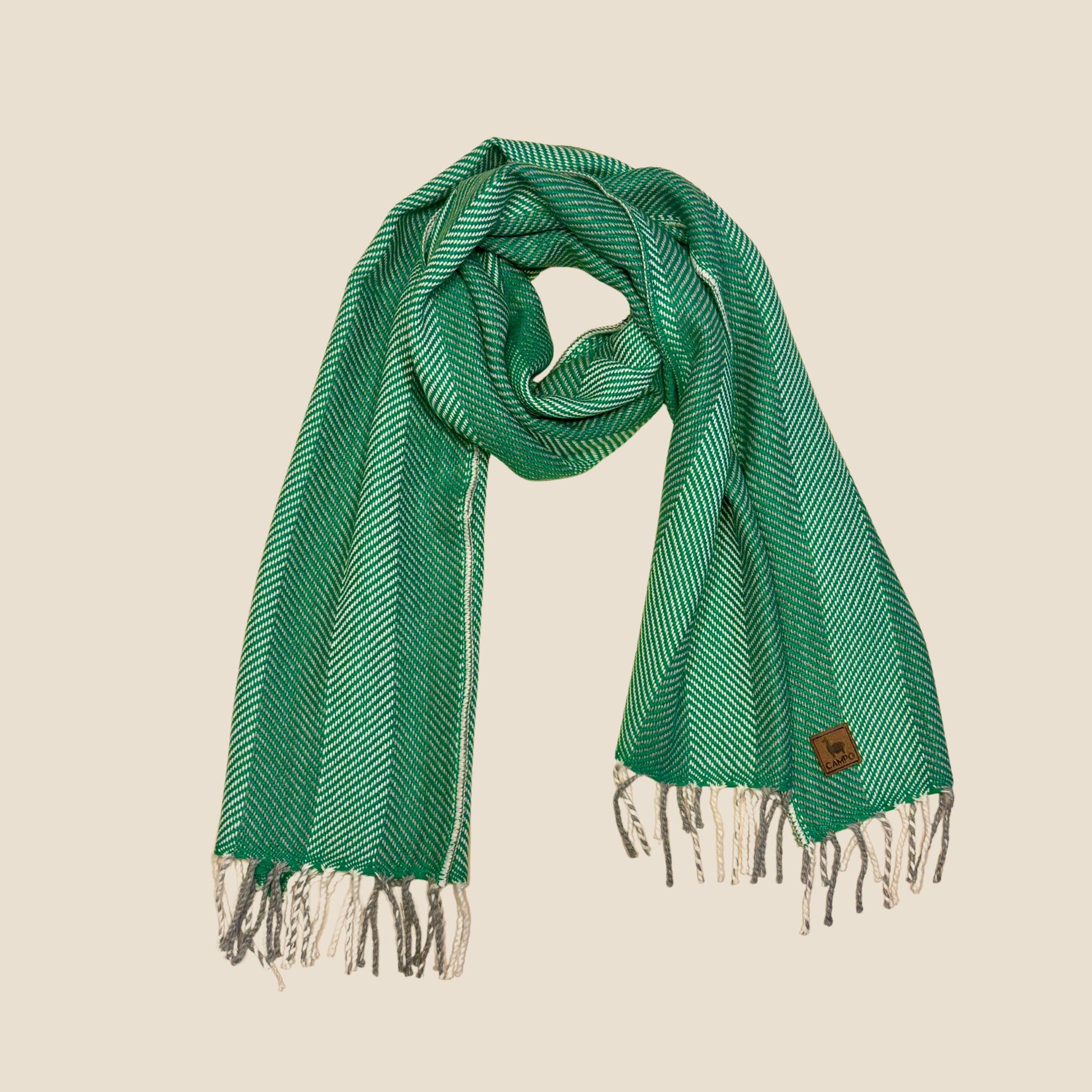 Green scarf with white stripes and fringes on a beige background