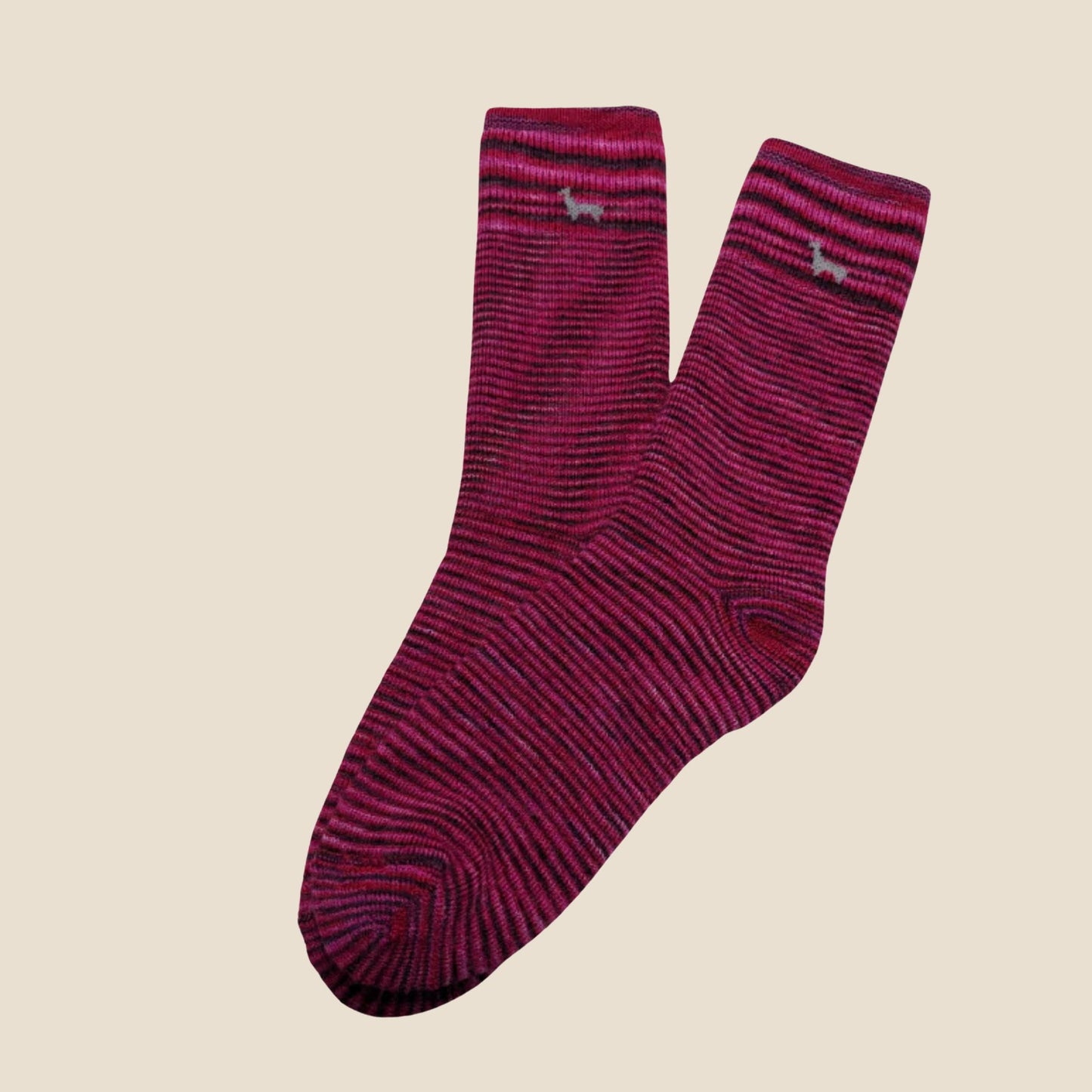 Pair of fuchsia socks with a subtle pattern on a beige background