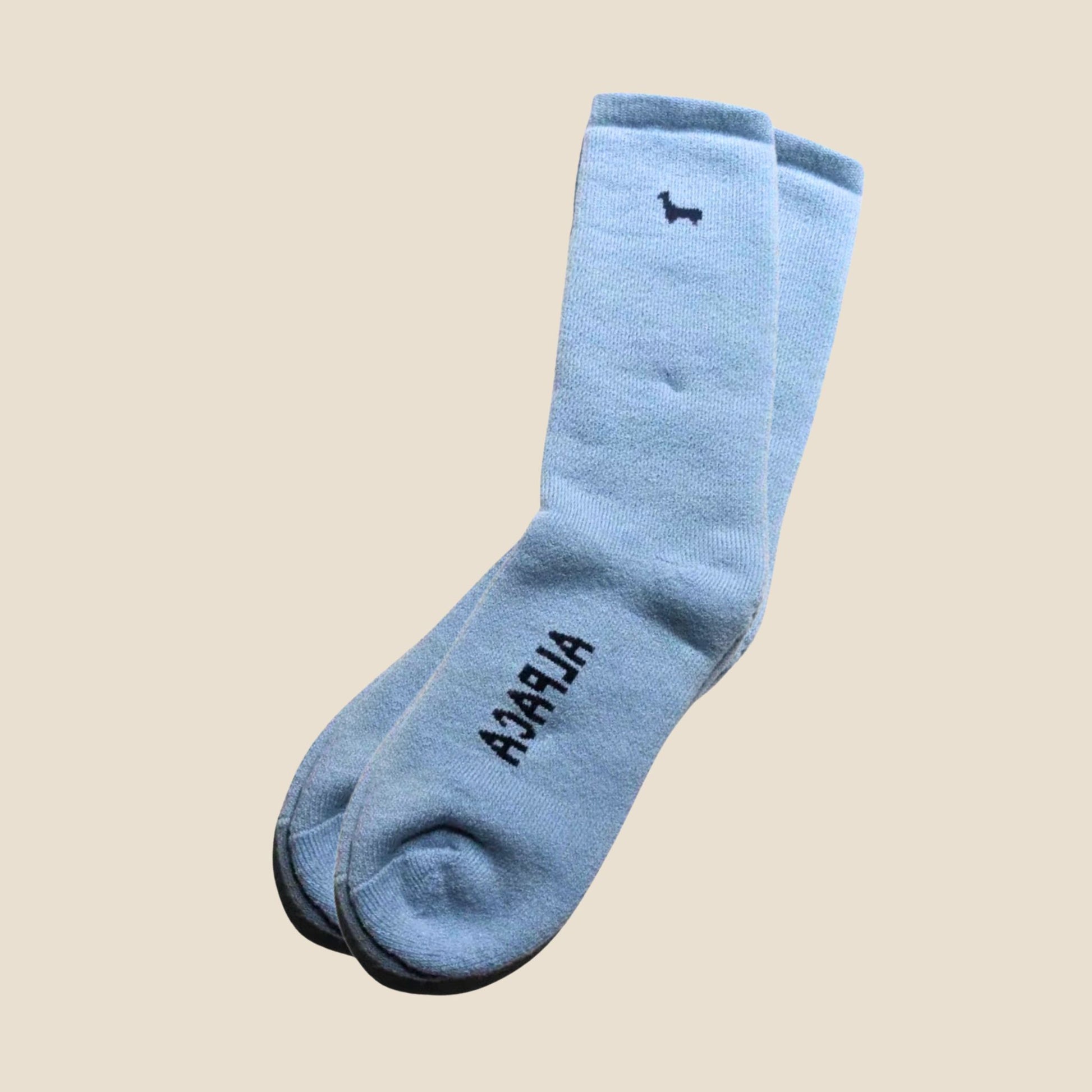 Pair of light blue socks with black text on a beige background