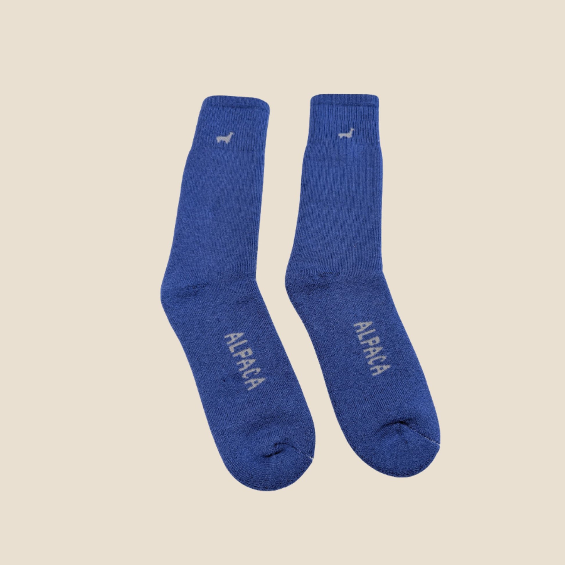 Pair of lilac socks with 'ALPACA' branding on a beige background