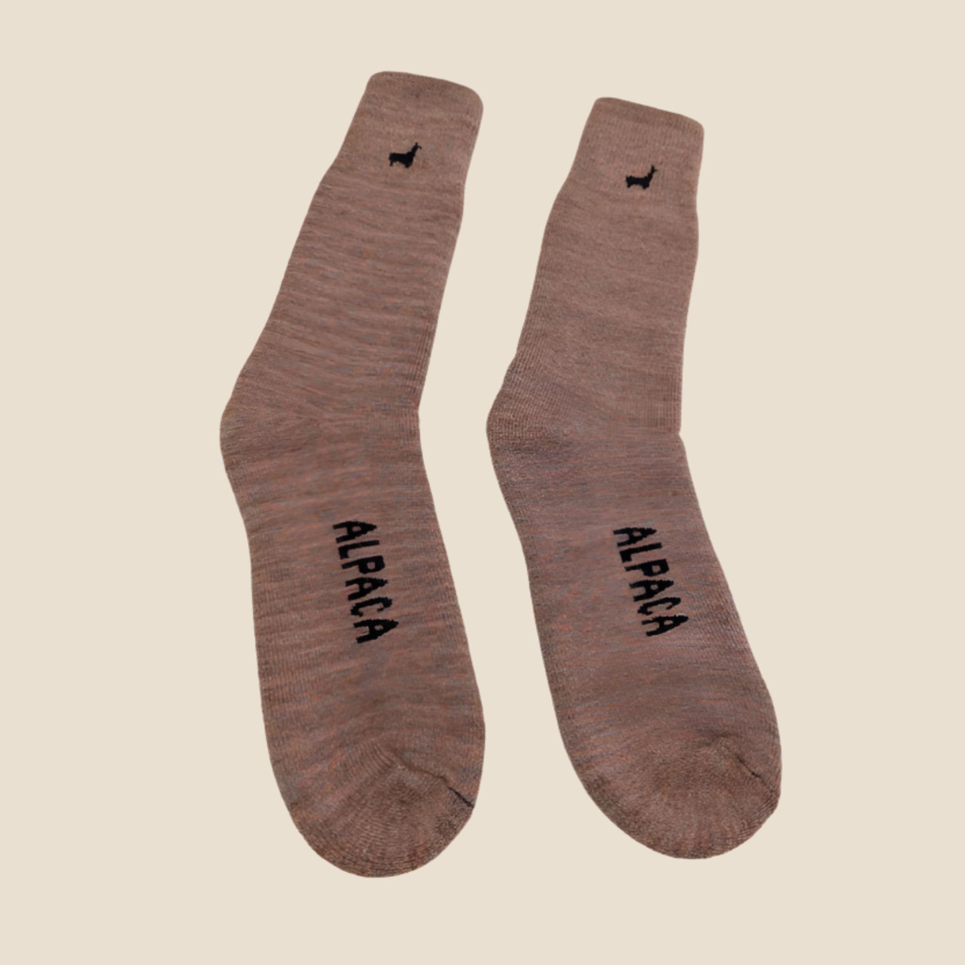 Pair of Peach socks with 'Alpaca' text on a beige background