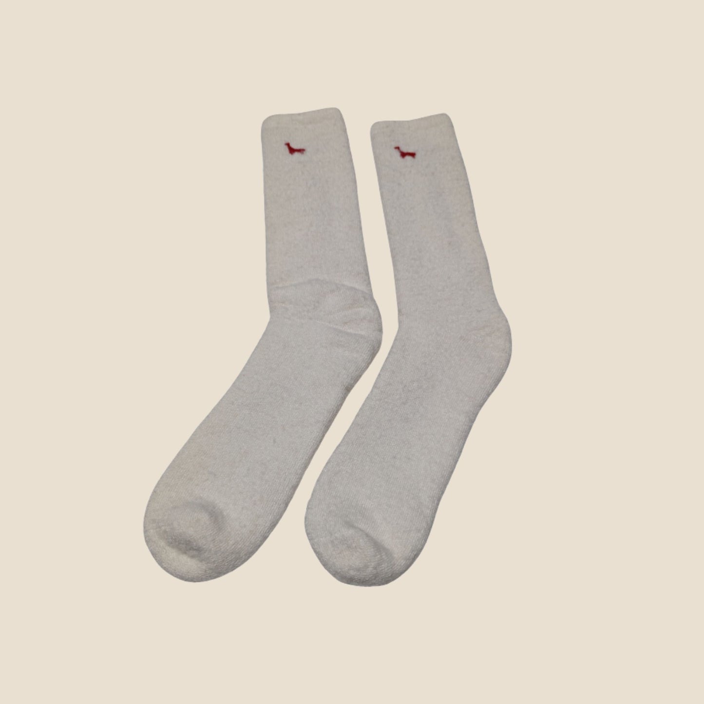 Pair of pearl  socks with small red alpaca illustrations on a beige background
