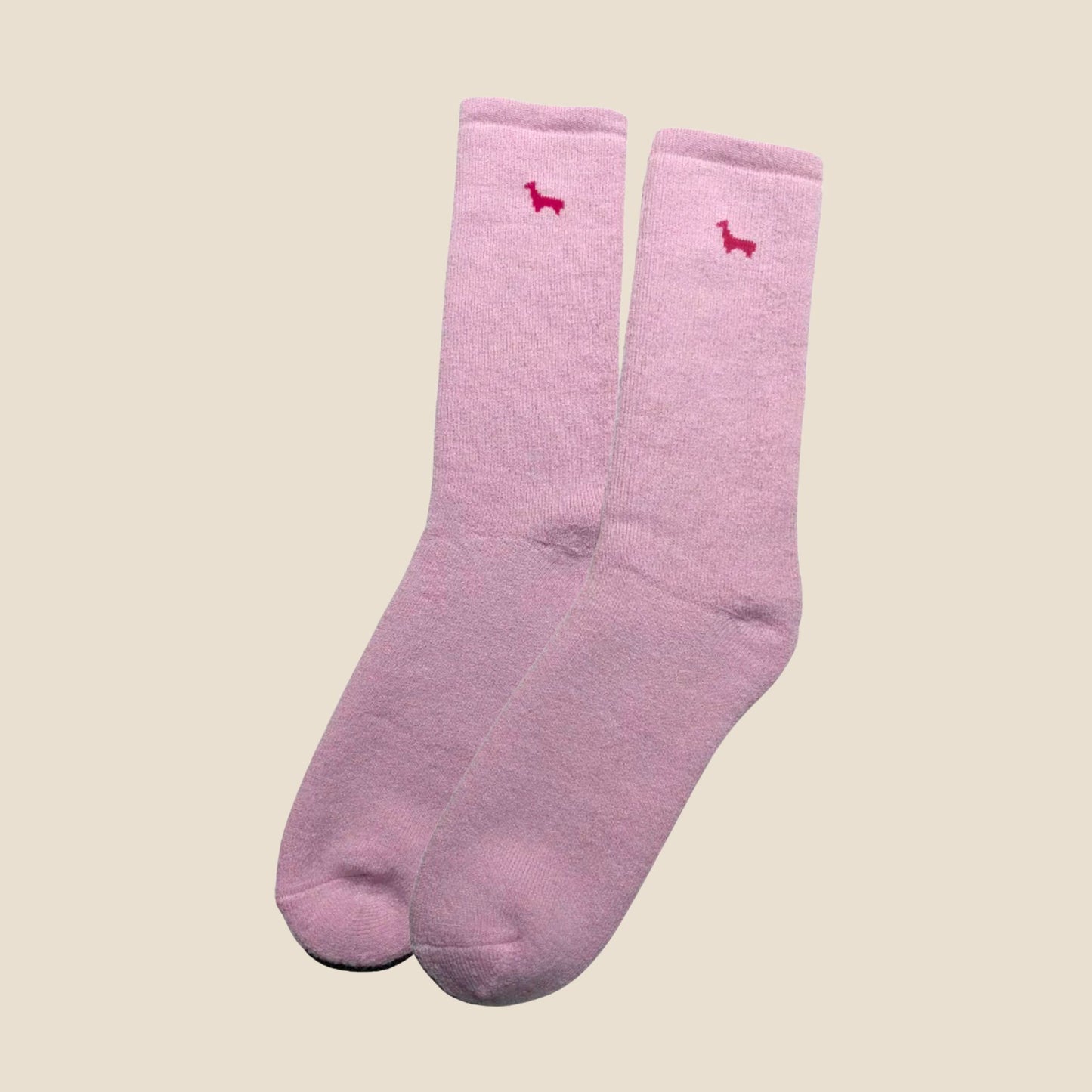Pair of pink socks with small red logos on a beige background