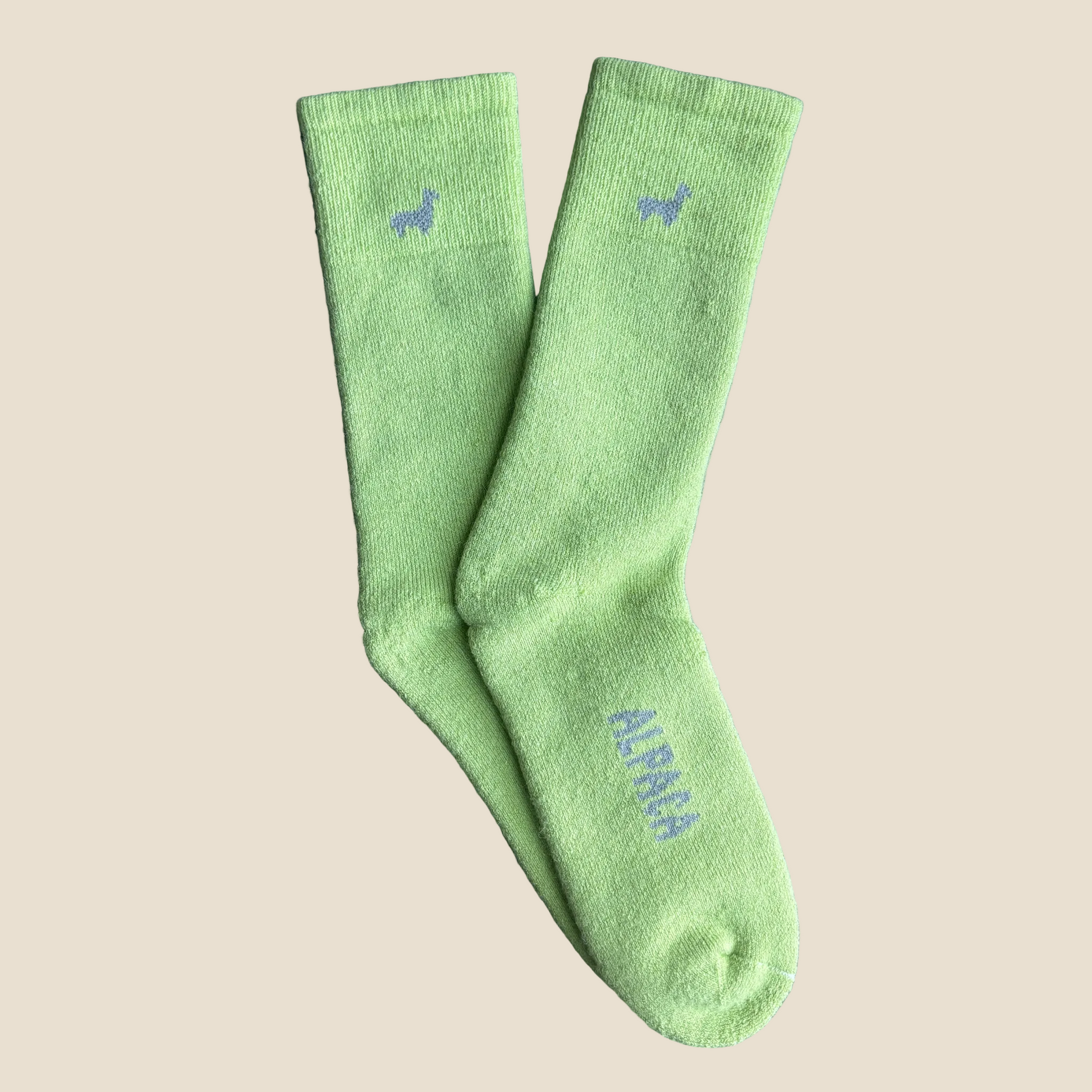 Green socks with branding on a beige background