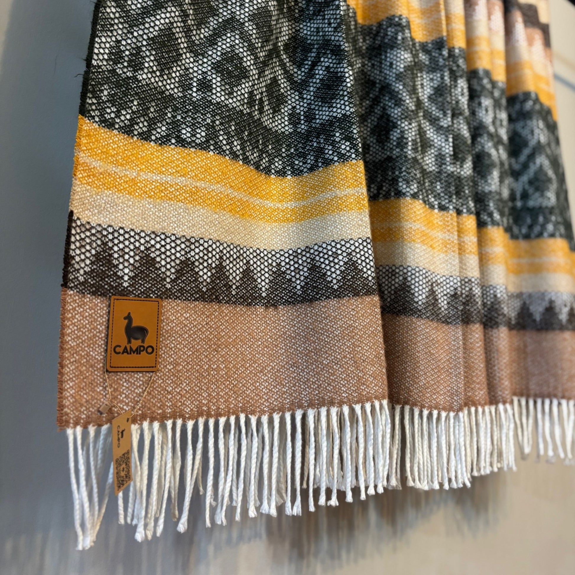 Green medley textured blanket with a 'Campo' brand tag on a neutral background