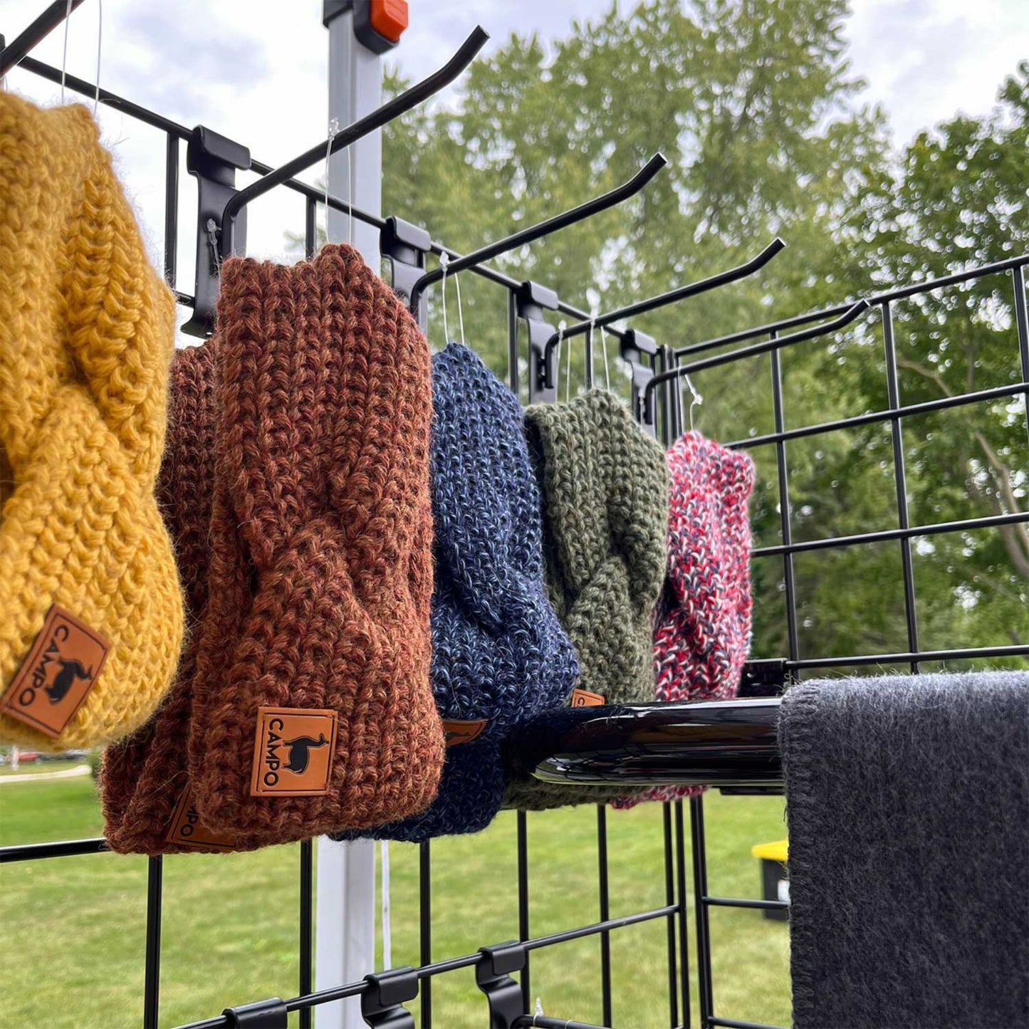 Colorful twisted headbands  hanging on a rack outdoors.