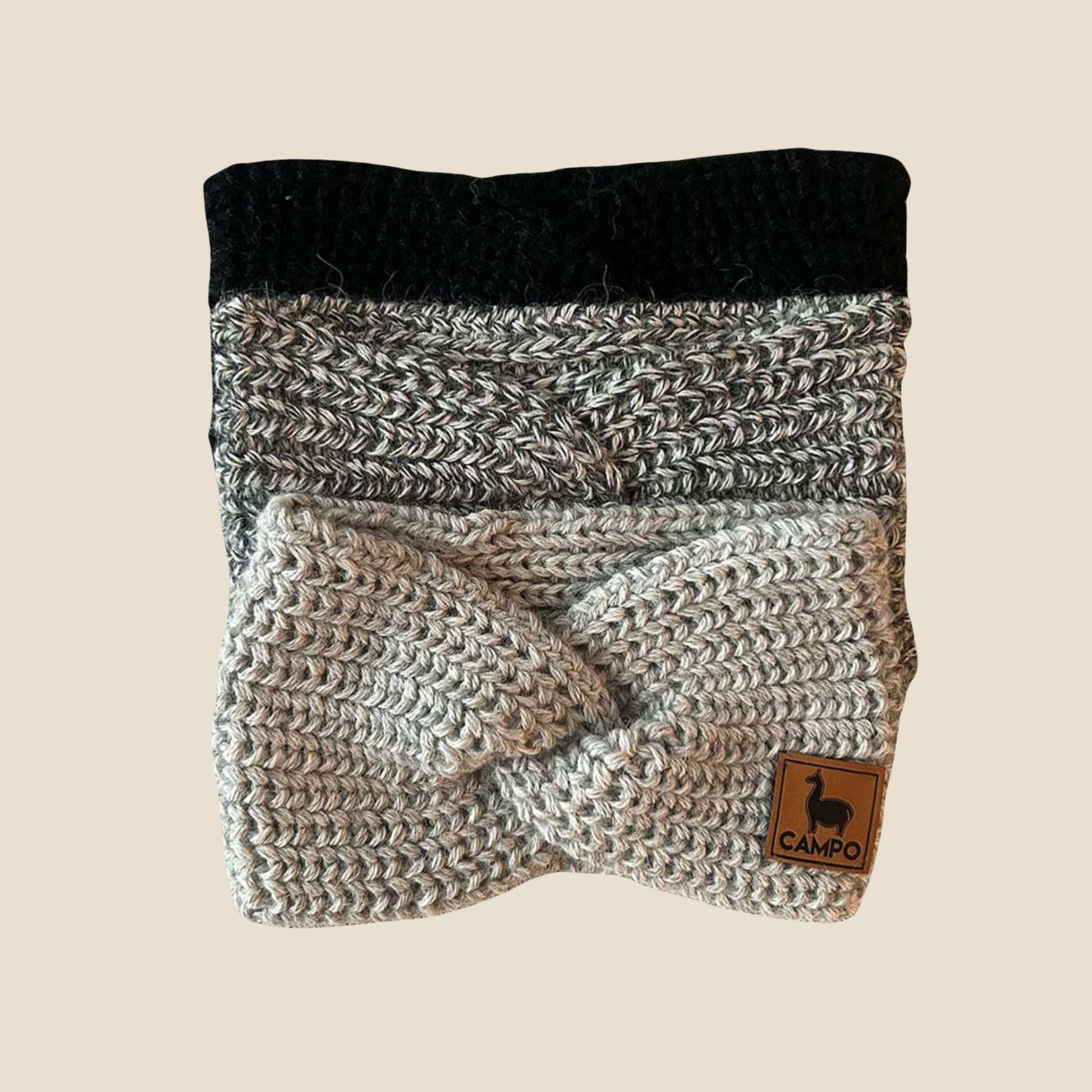 Knitted product with black top and gray bottom on a beige background, featuring a 'Campo' brand label.