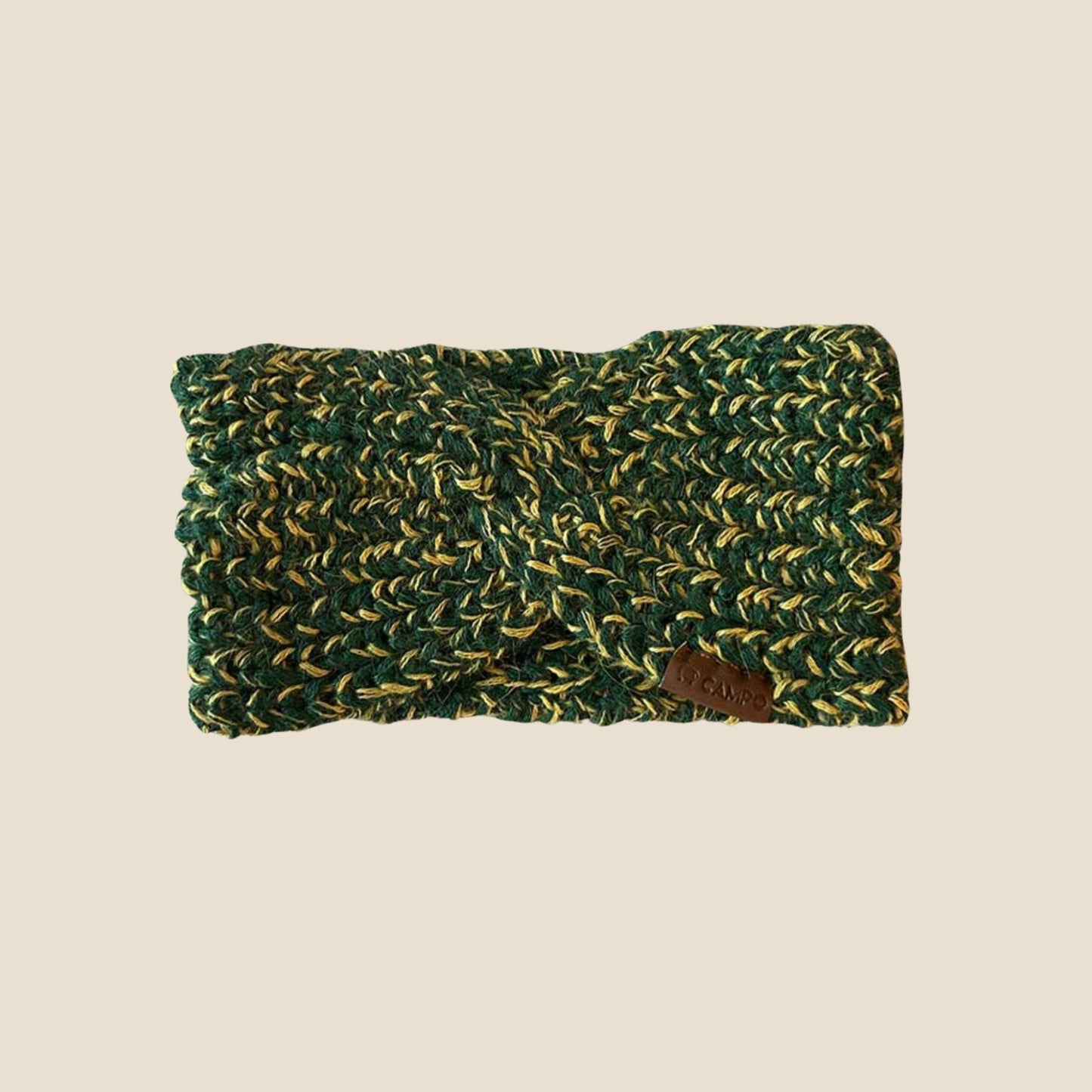 Green and yellow knitted headband on a beige background
