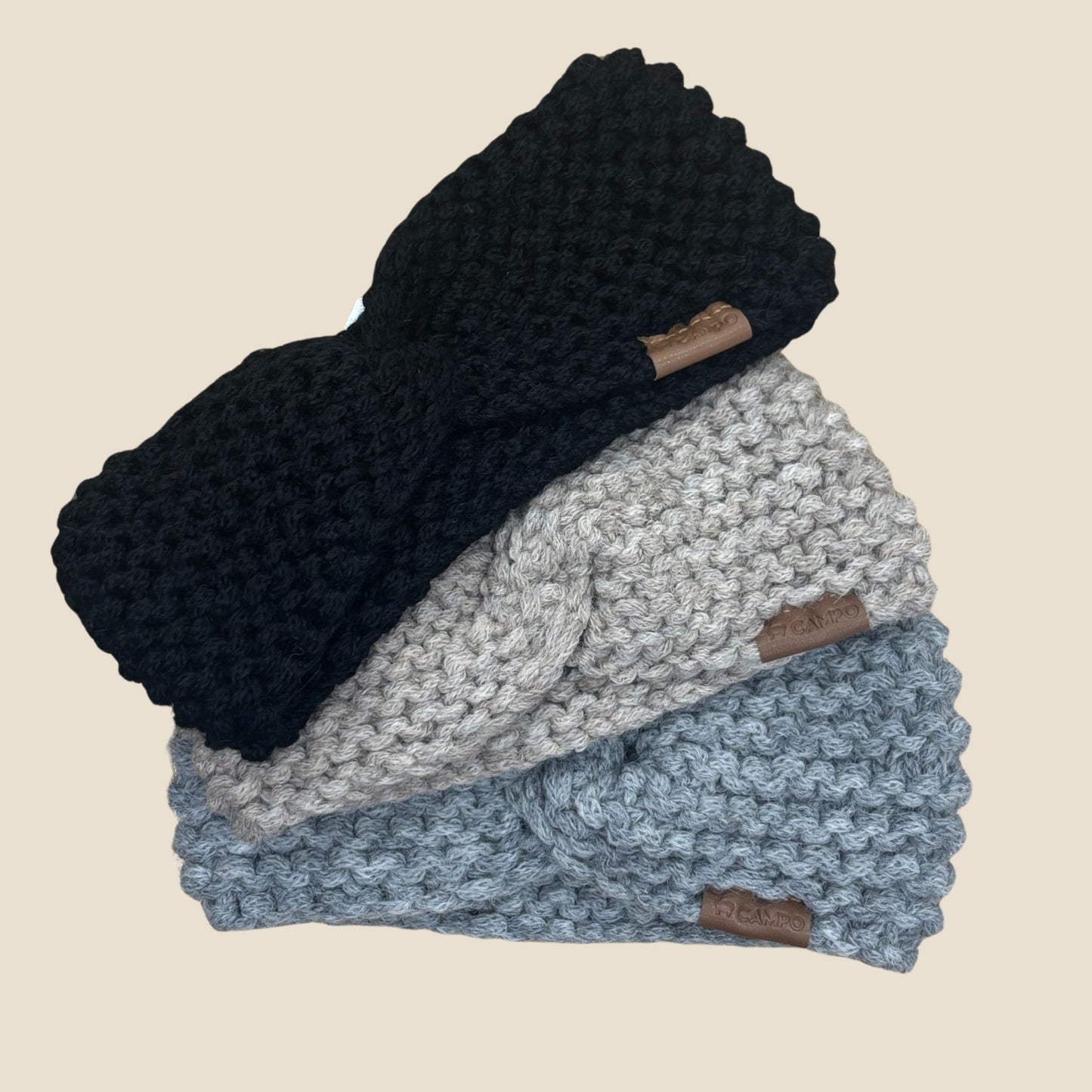 Stack of three twisted headbands on a beige background