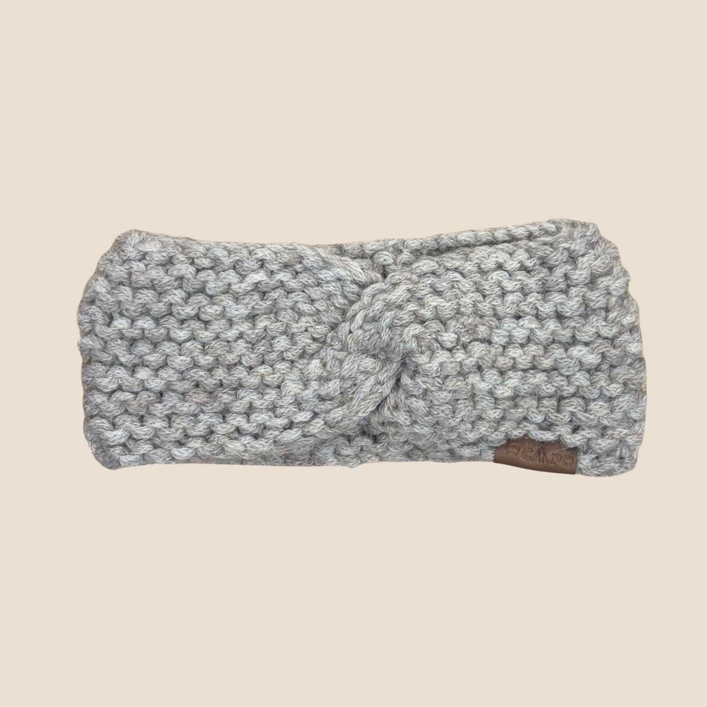 Oatmeal twisted headband with a knot on a beige background