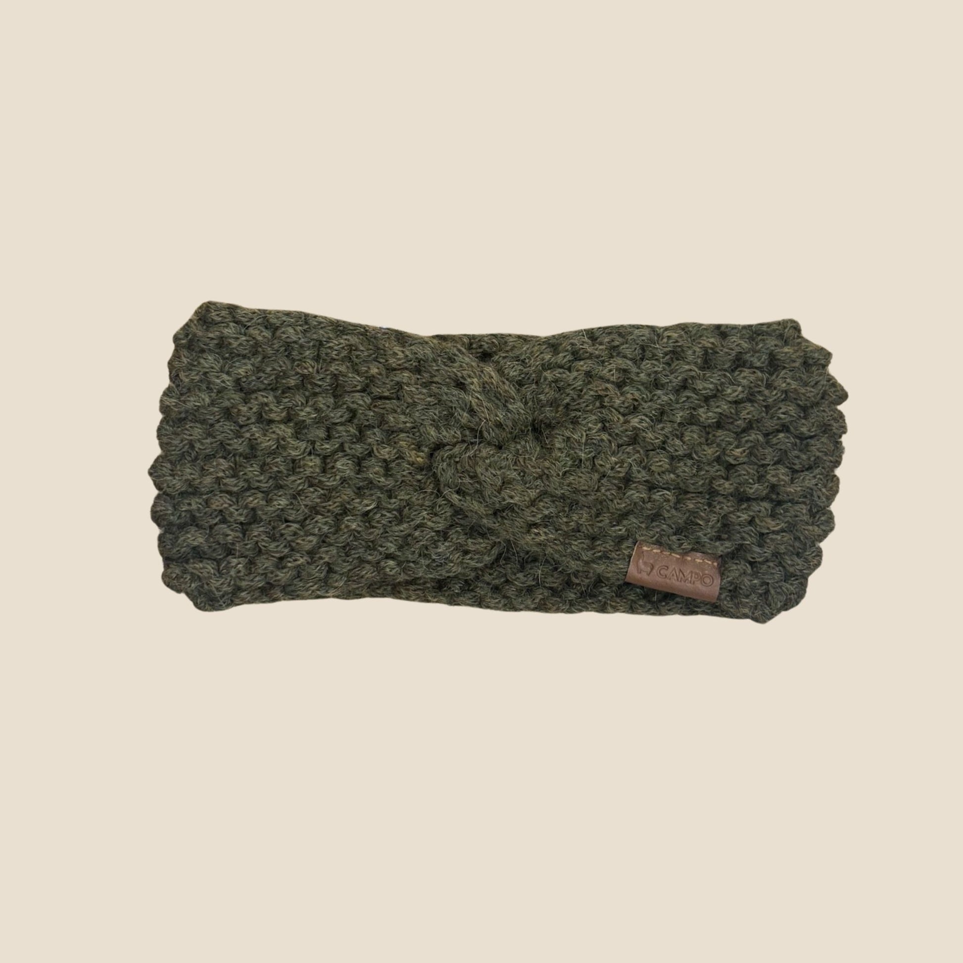 Olive Green knitted headband with a brand label on a beige background