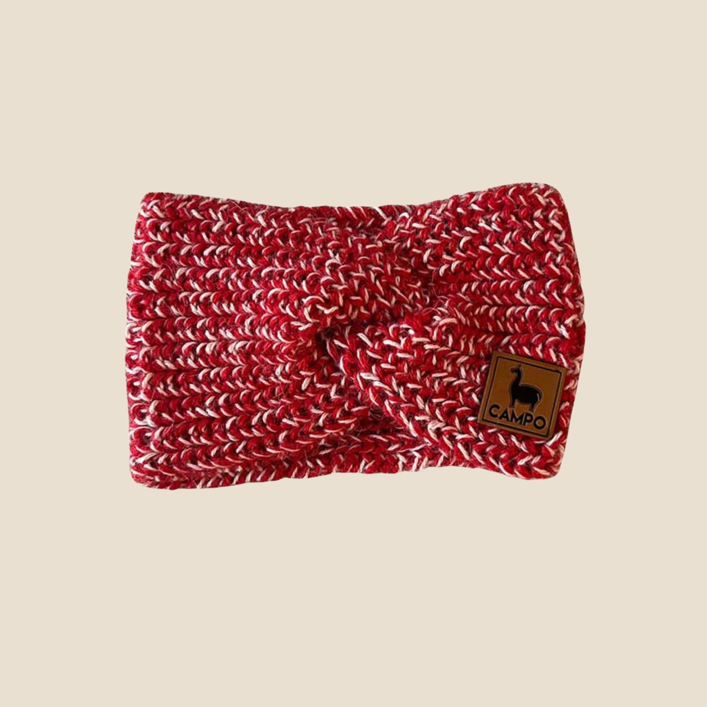 Red and white twisted headband with a brand logo on a beige background