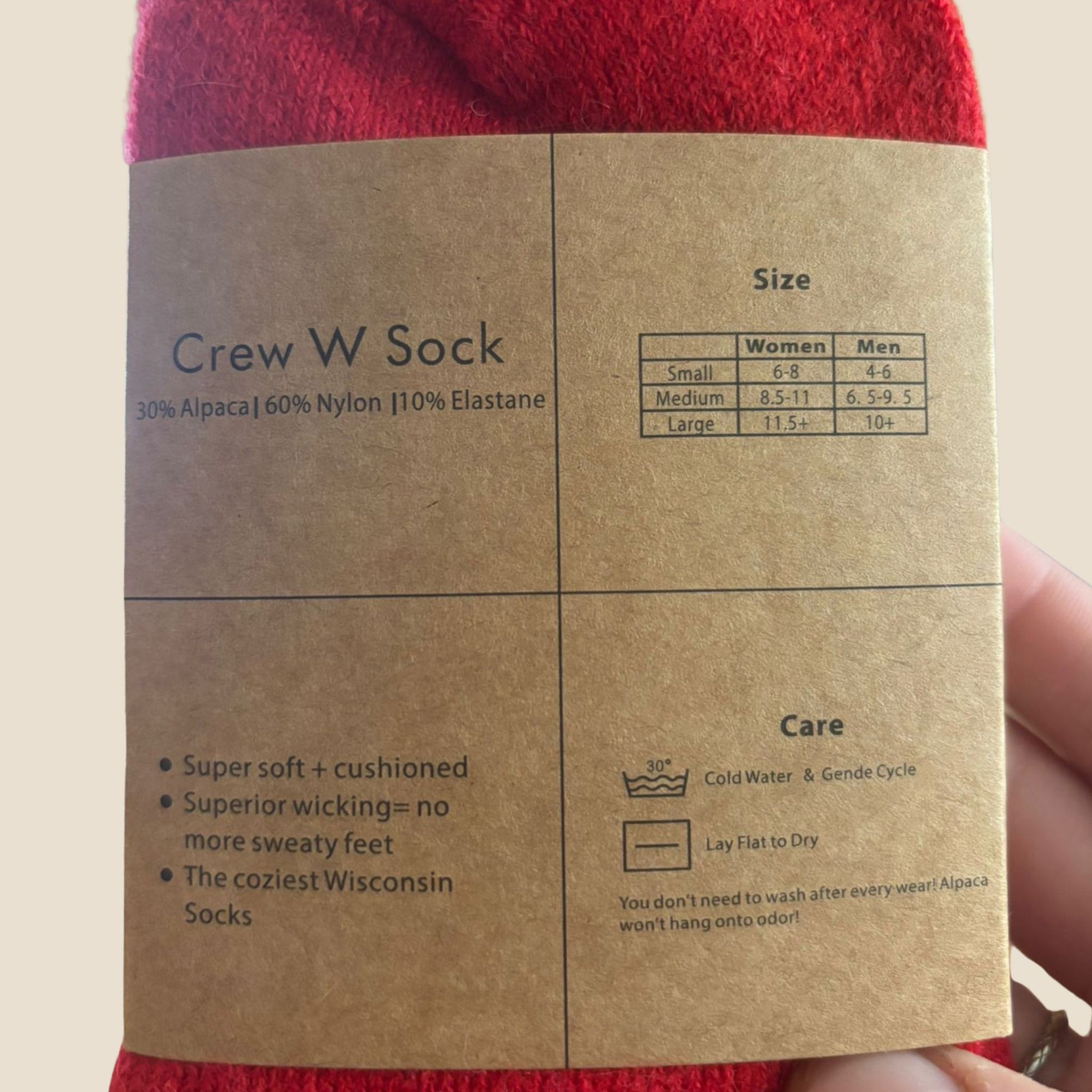 Close-up of a brown label on red socks with text about the size