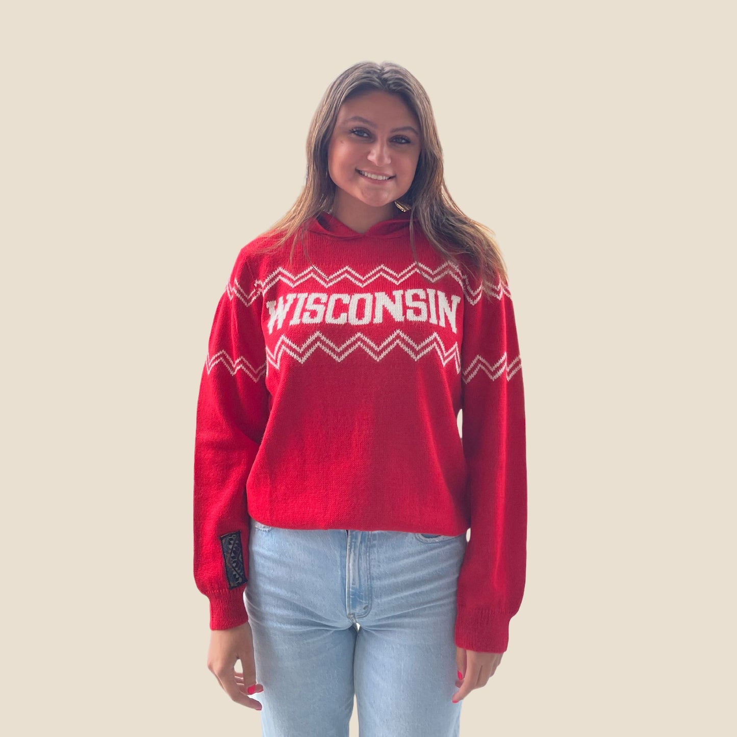 Person wearing a red 'WISCONSIN' sweater on a plain background