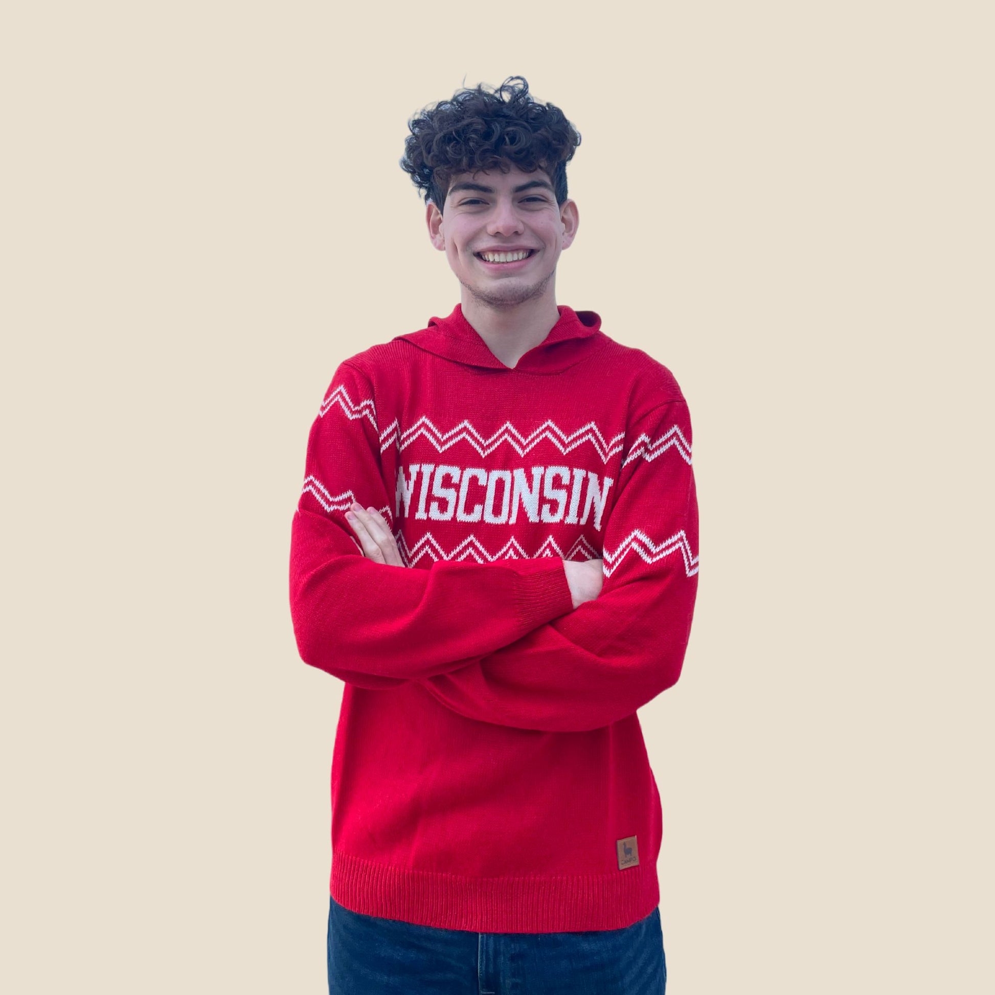 Person wearing a red 'Wisconsin' hoodie against a beige background