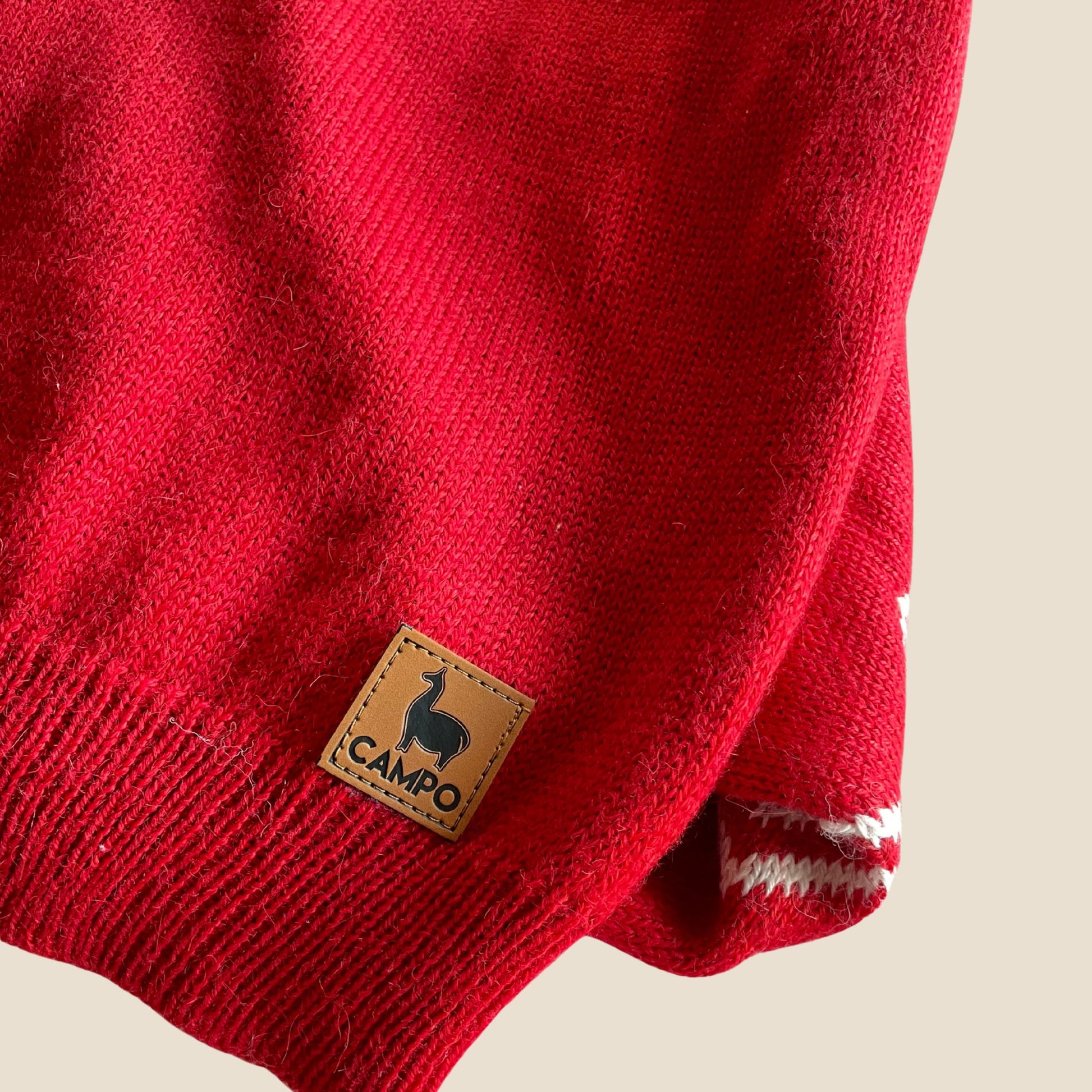 Red sweater with a 'Campo' brand label on a beige background