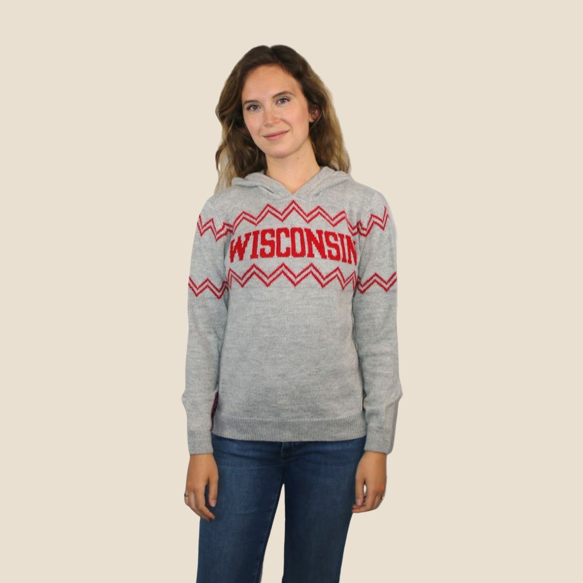 Person wearing a gray hoodie with 'Wisconsin' printed on it against a beige background