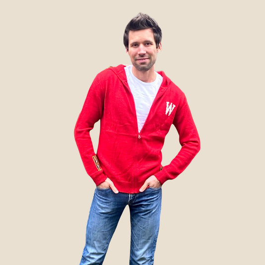 Man wearing a red hoodie with a white 'W' logo on a beige background