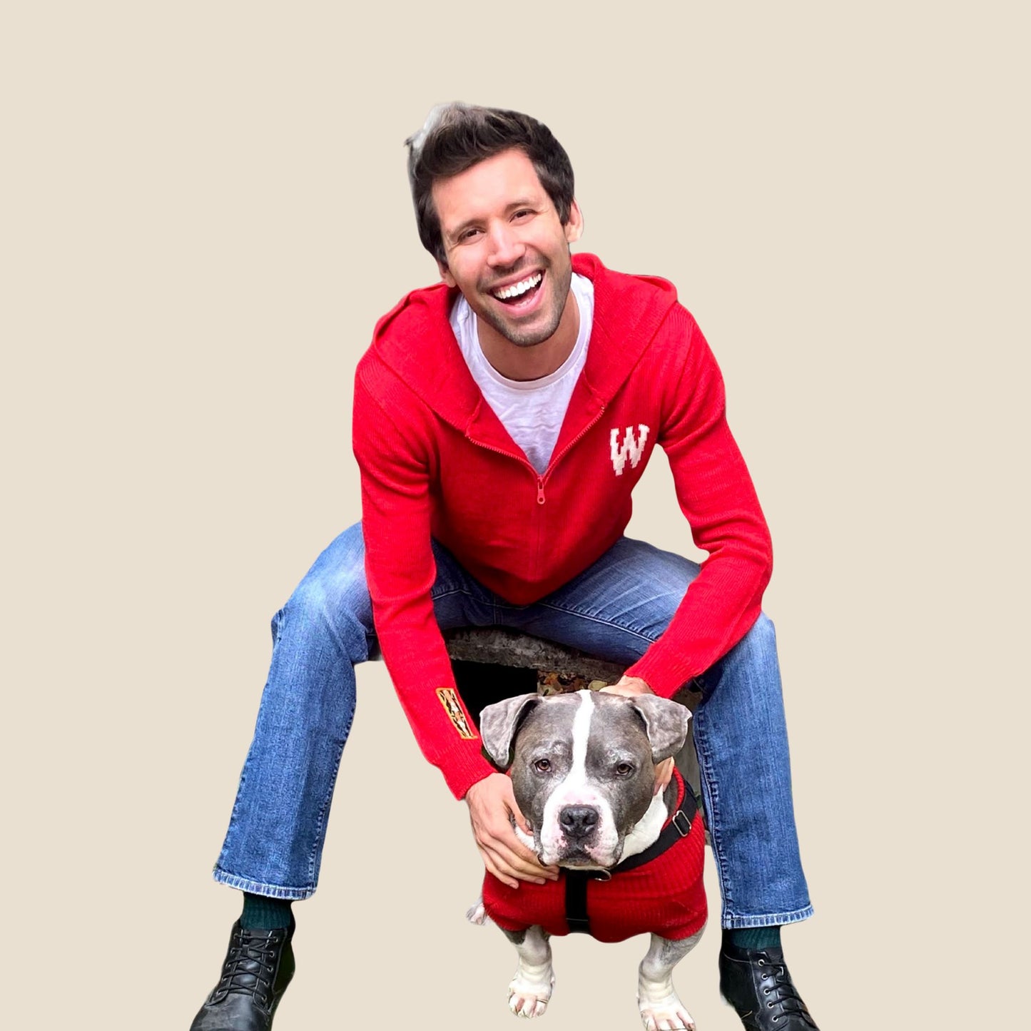 Man in a red hoodie with a dog on a beige background