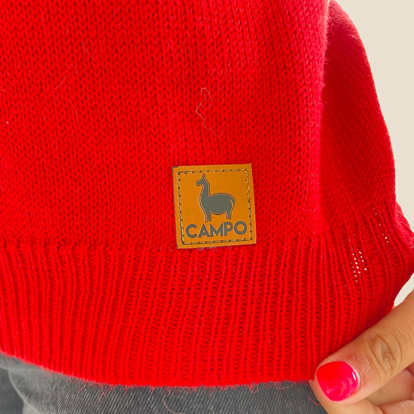 Red sweater with a 'Campo' brand label on a neutral background