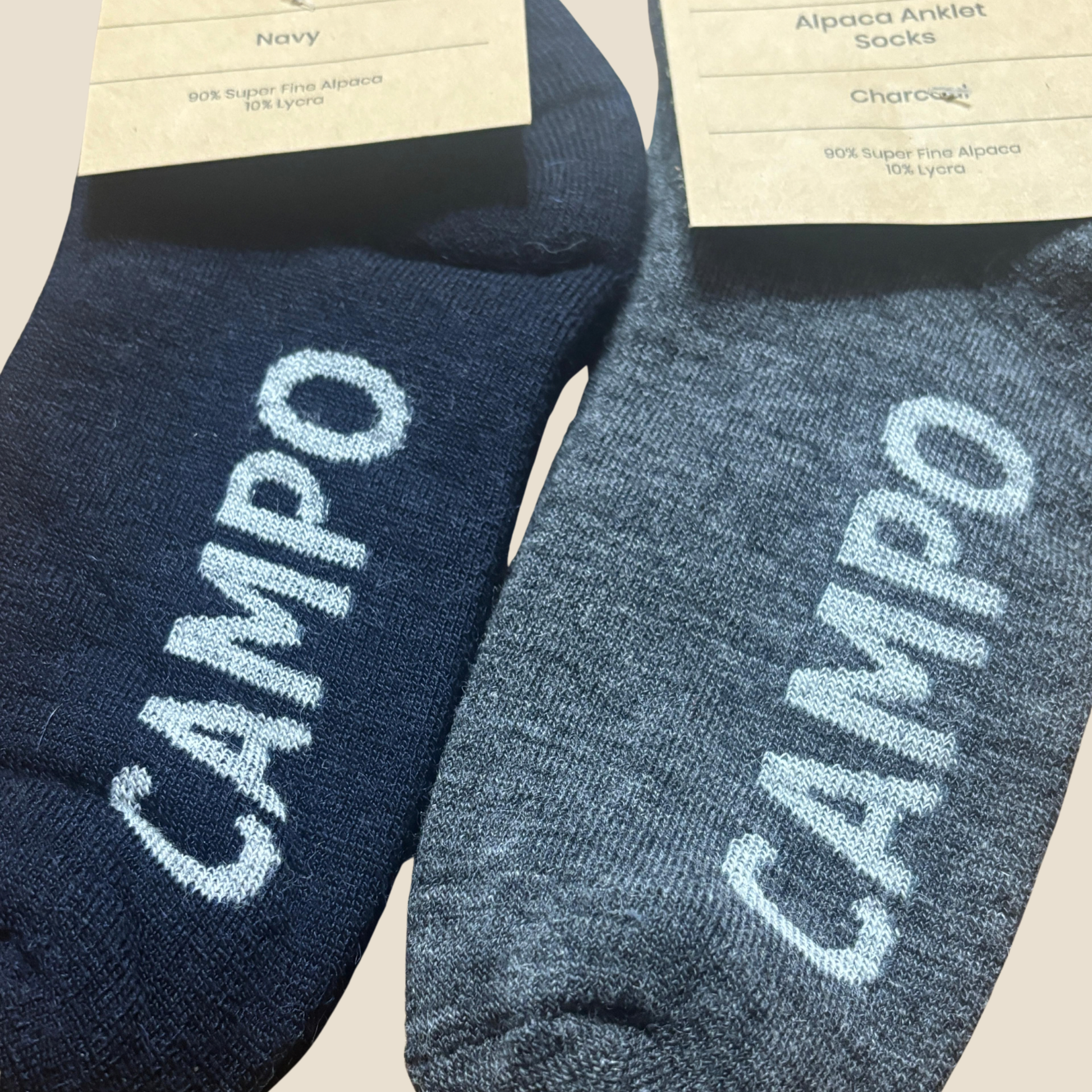 Two pairs of socks with 'CAMPO' branding on a neutral background