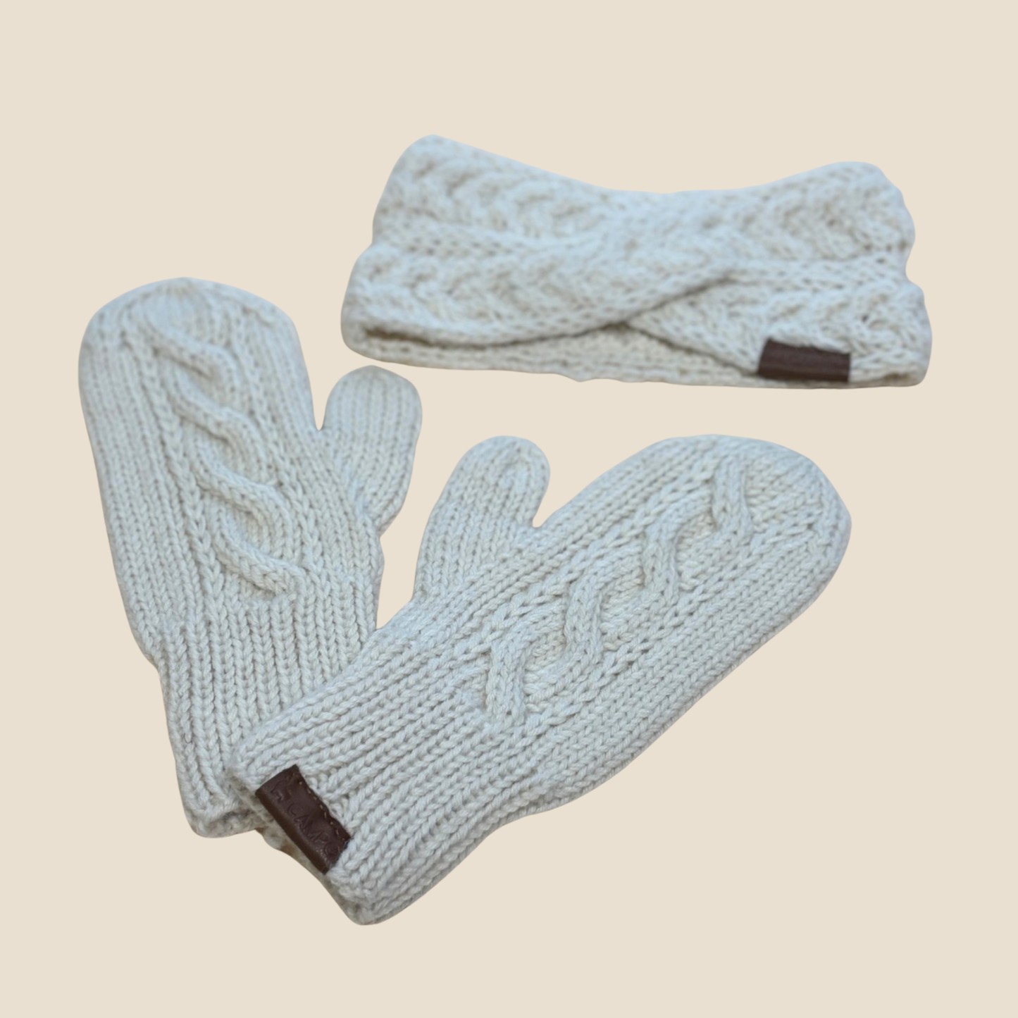 Pair of white mittens and headband set on a beige background