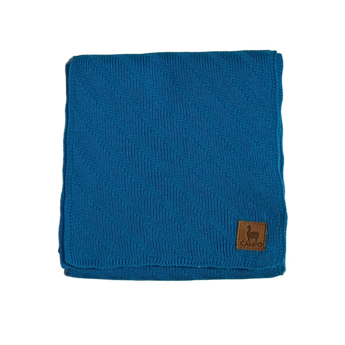 A folded teal blue ribbed knit blanket or throw with a small brown leather CARGO logo patch in the bottom right corner, displayed on a light textured background.