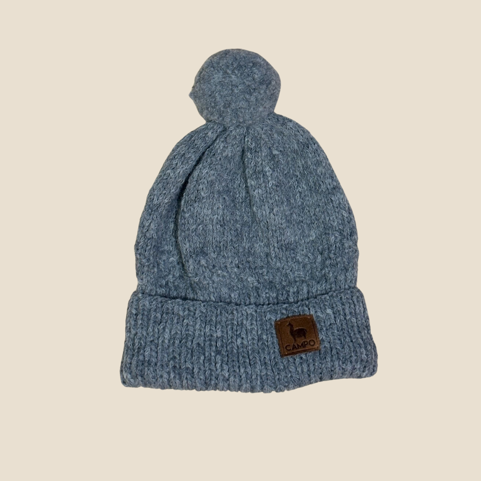 Gray knit beanie with a brand label on a beige background
