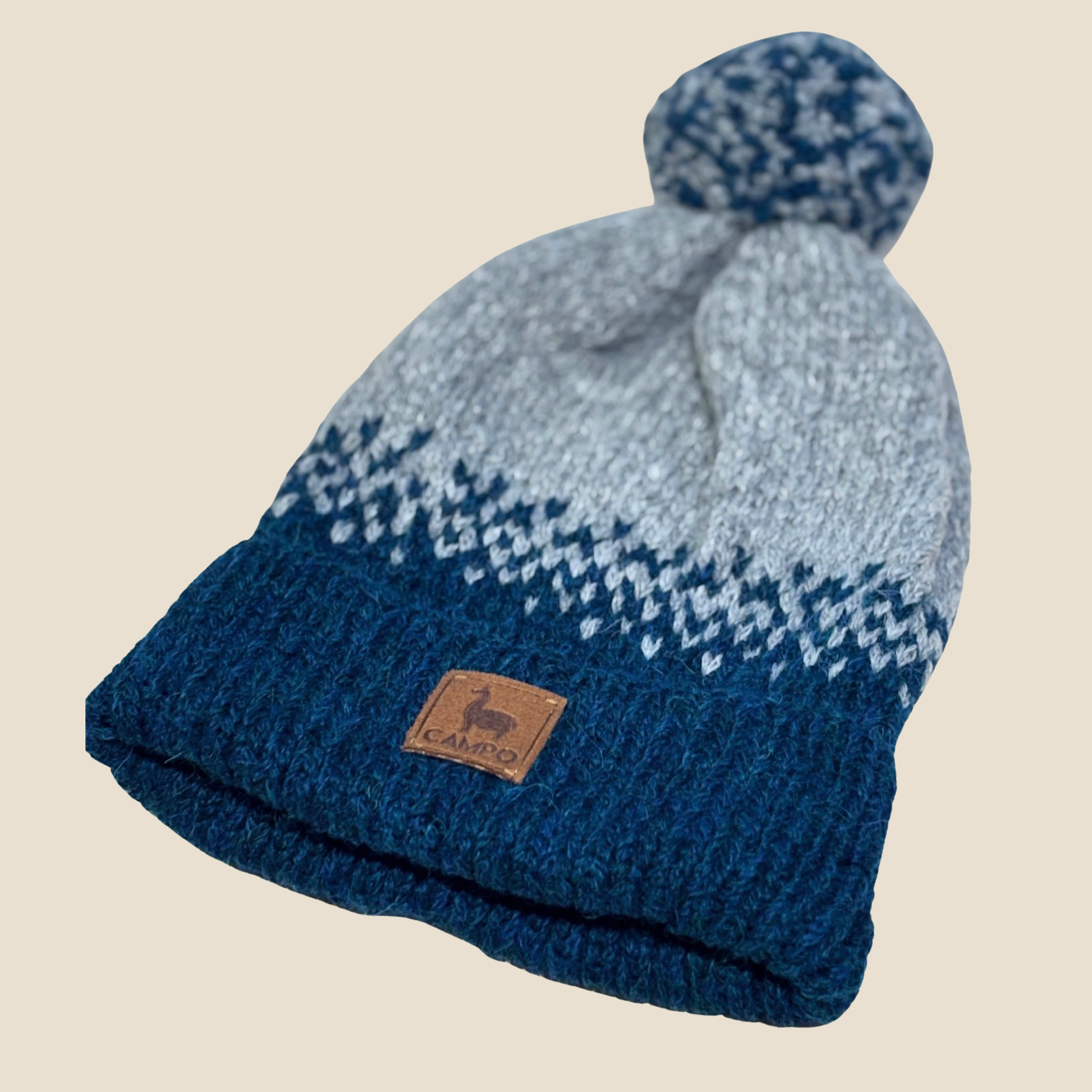 Knitted beanie with blue and gray pattern on a beige background