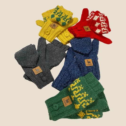 Set of colorful knitted gloves and hats on a beige background